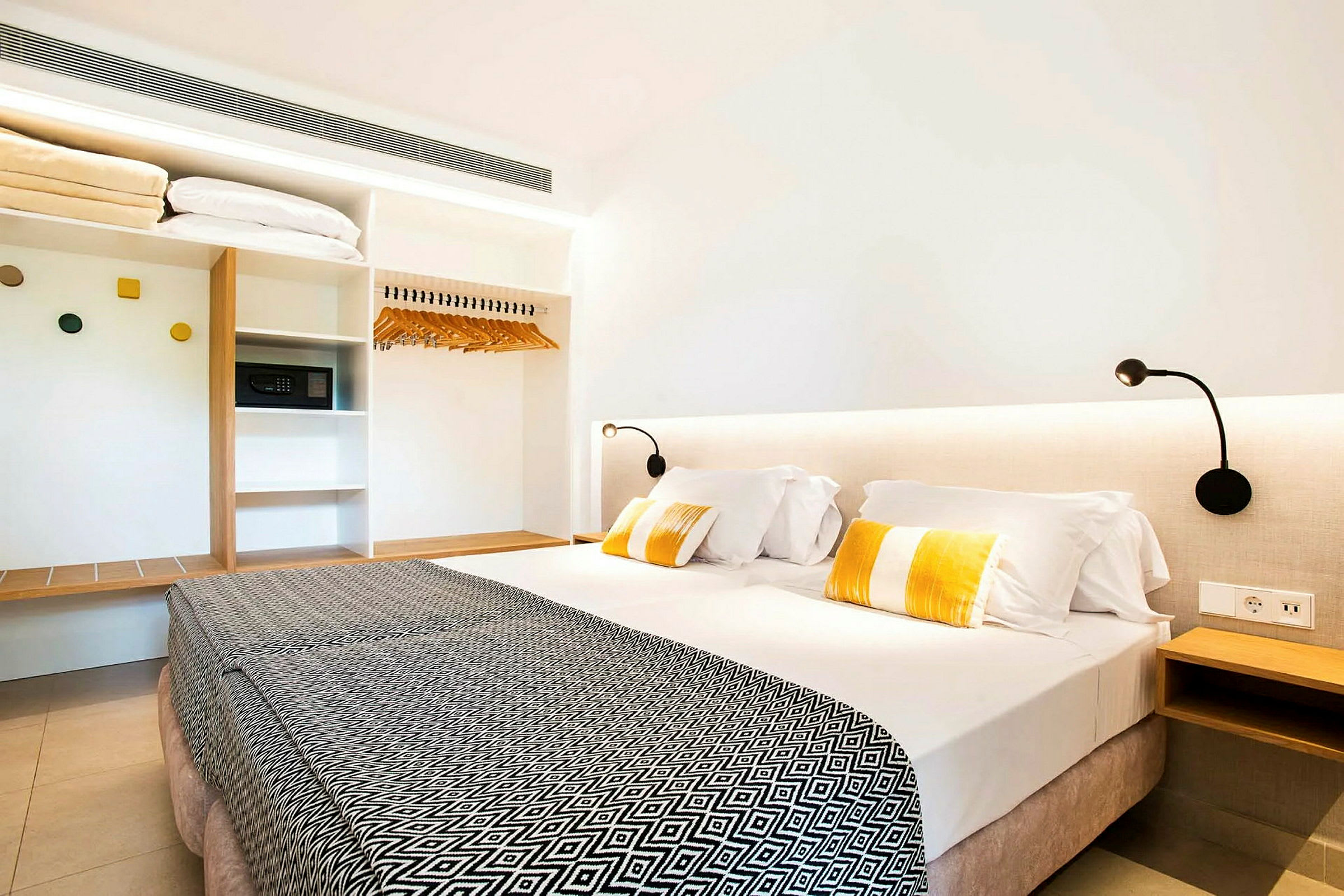 Hotelværelse med en dobbeltseng, sengelamper og et garderobeskab. (AI-genereret tekst)