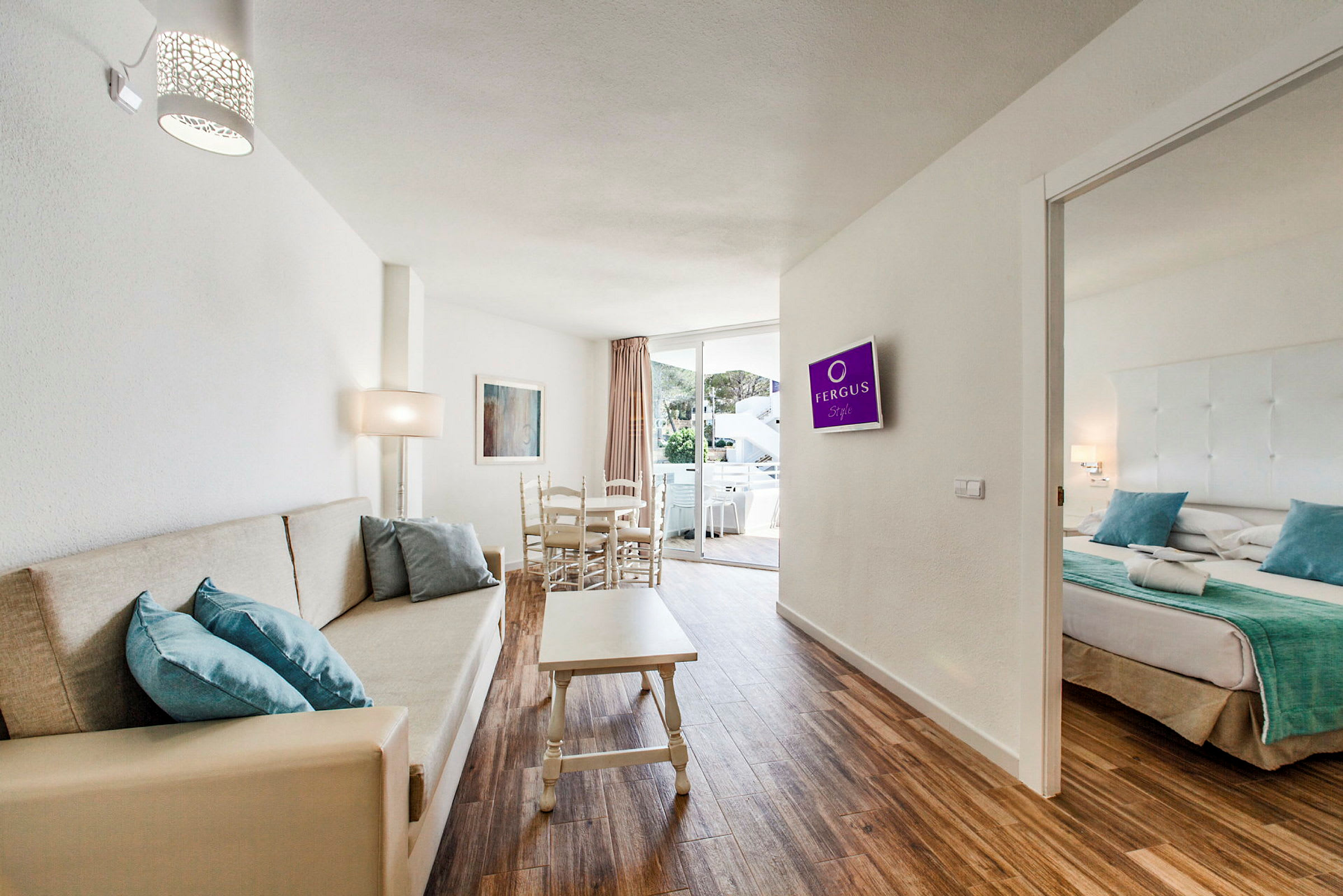 Billede af et hotelværelse med stue, sofa, spisebord og tilstødende soveværelse. (AI-genereret tekst)
