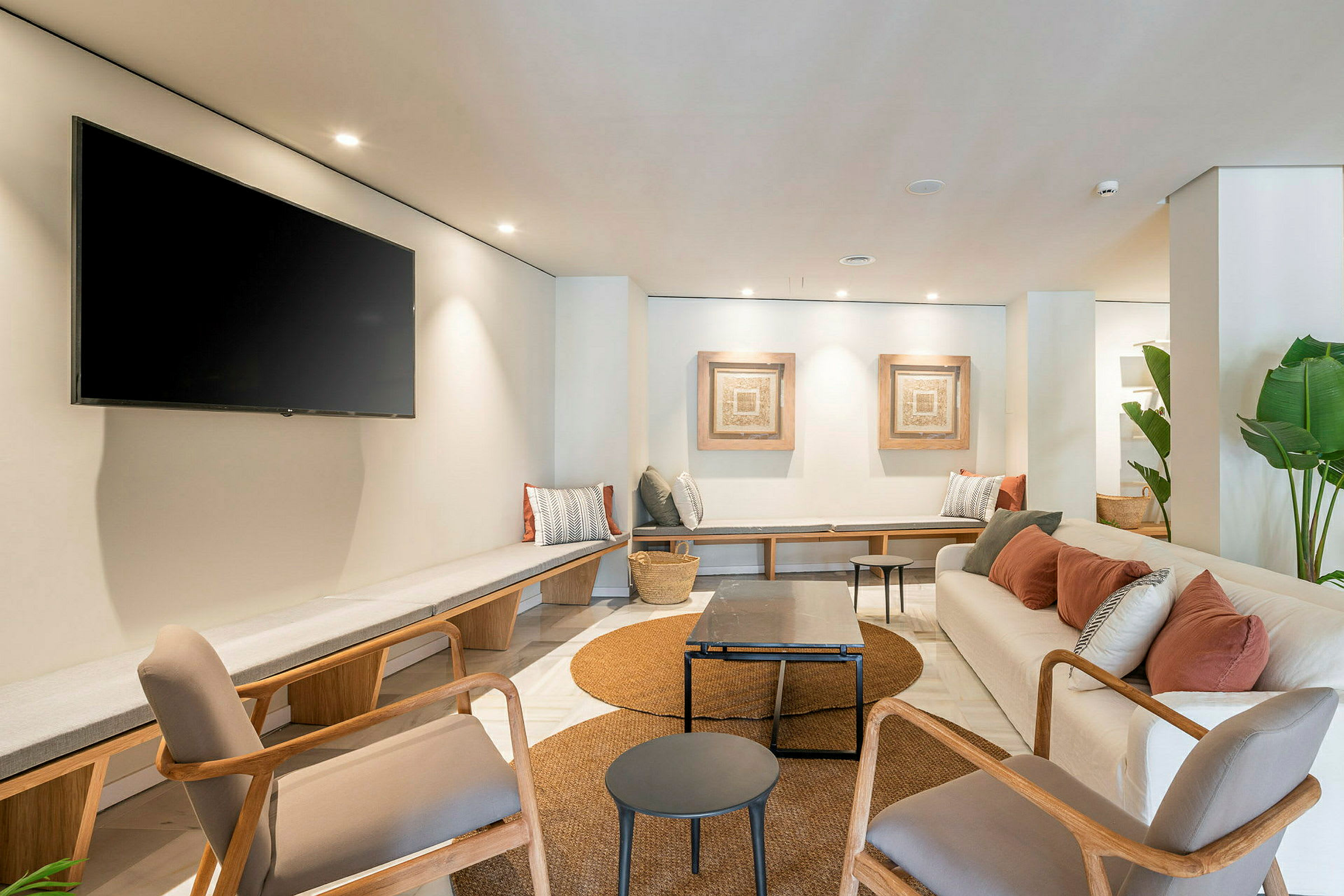 Moderne møbleret lounge med siddepladser, borde og vægdekorationer. (AI-genereret tekst)