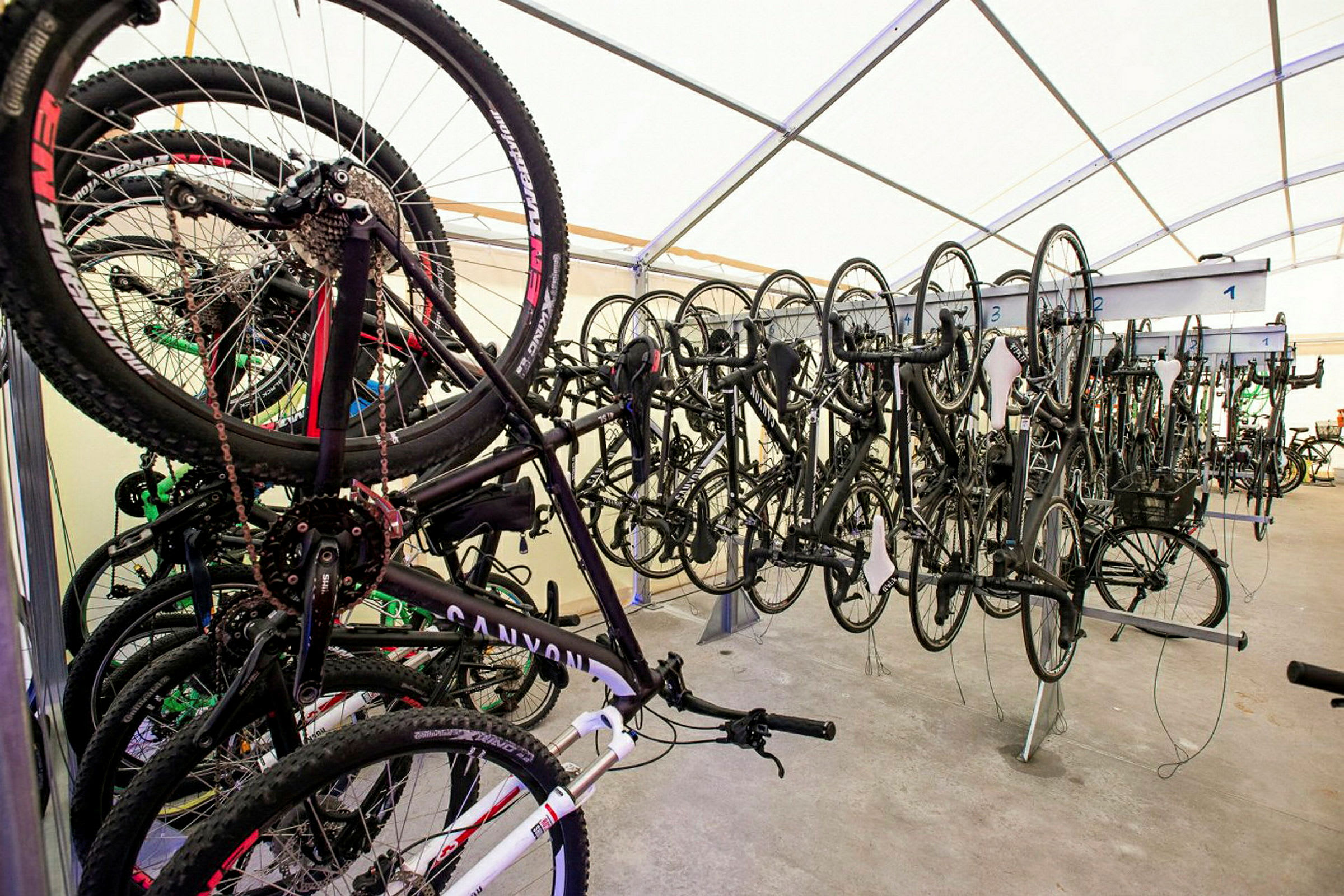 Cykler opbevares hængende på række indendørs. (AI-genereret tekst)