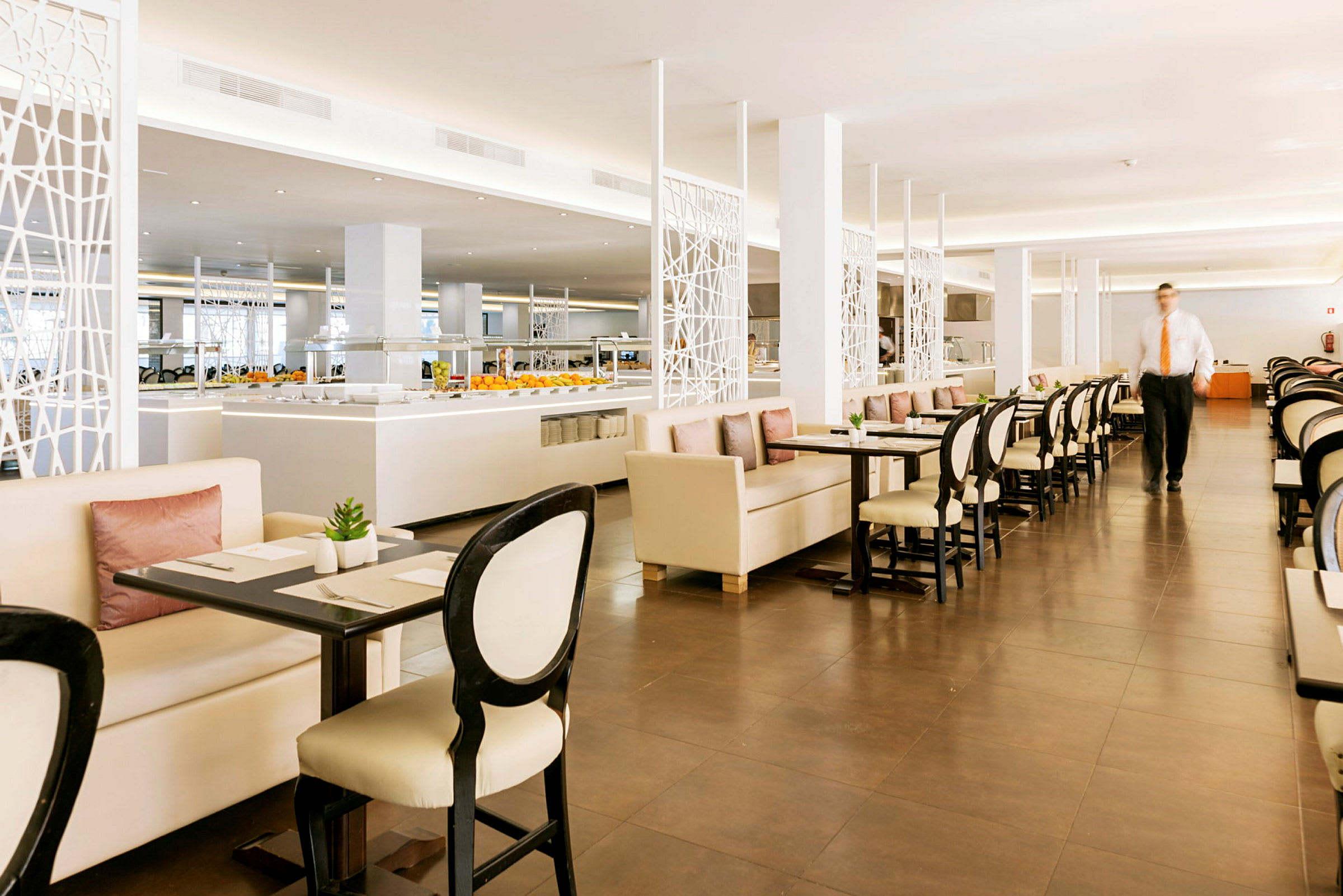 En restaurant med borde og stole samt en buffetservering i baggrunden. (AI-genereret tekst)