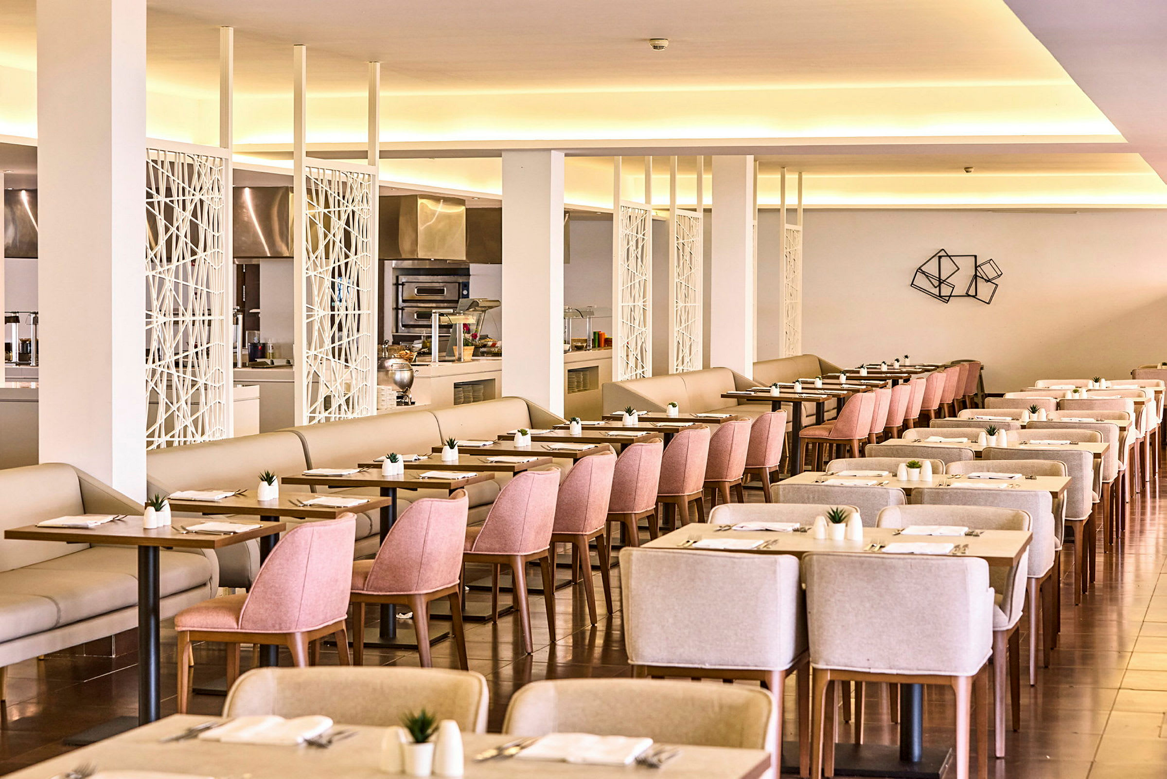 Et rummeligt hotelrestaurantområde med lys indretning og velordnede borde og stole. (AI-genereret tekst)