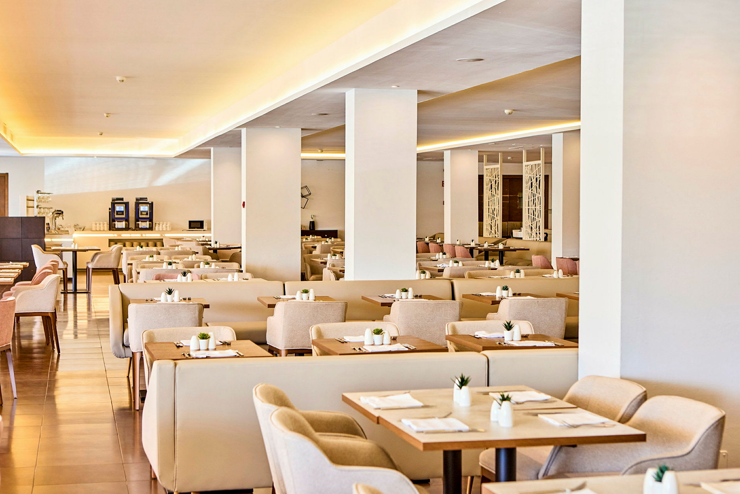 En elegant restaurant med opdækkede borde og beige stole. (AI-genereret tekst)