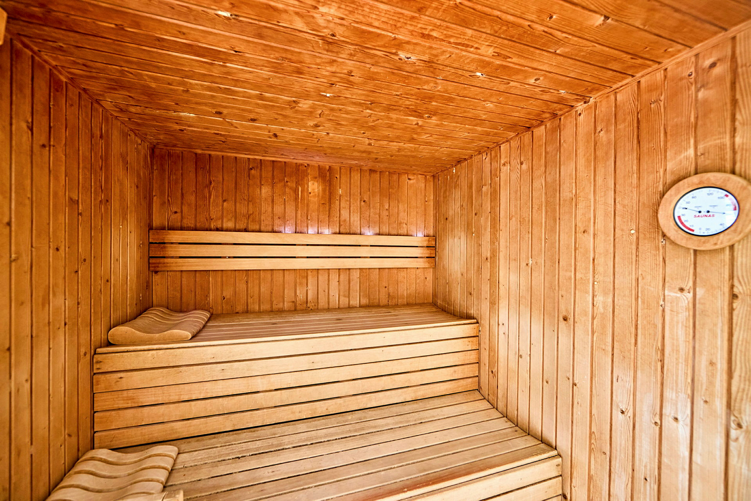 En traditionel sauna med træpaneler og træbænke. (AI-genereret tekst)