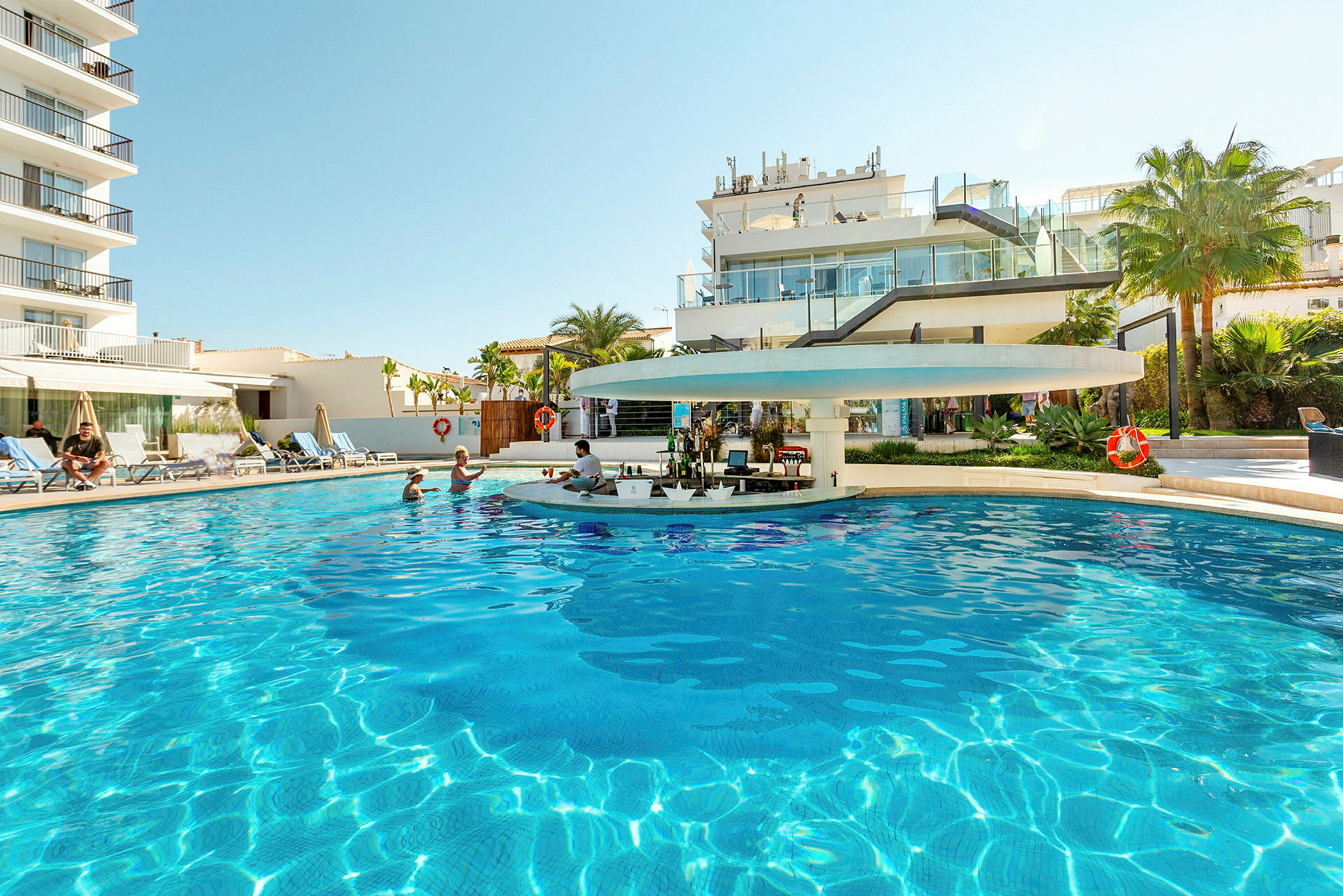 Hotelpool med bar og liggestole. (AI-genereret tekst)