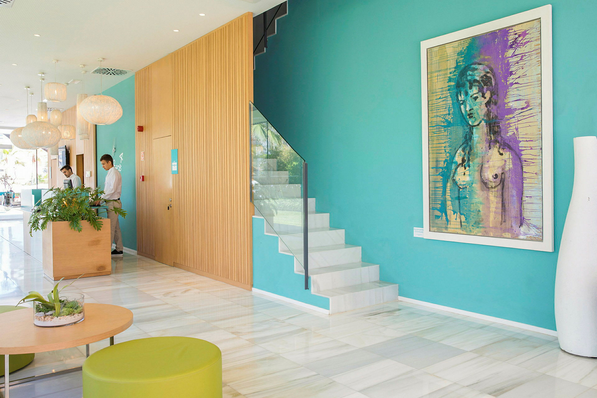 Hotellets elegante lobby med farverig kunst på væggene og moderne møbler. (AI-genereret tekst)