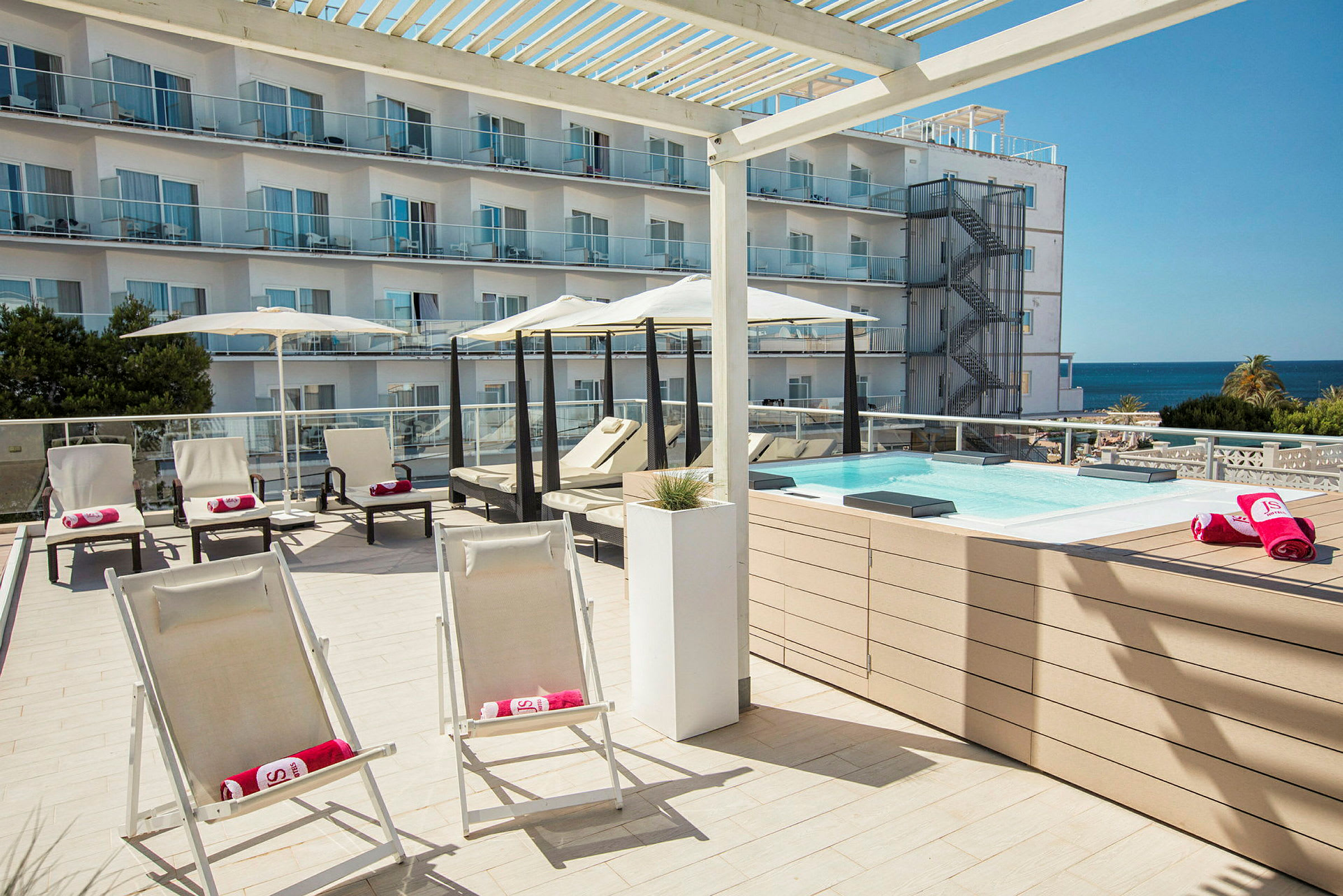 Liggestole og parasoller ved en lille pool på en terrasse. (AI-genereret tekst)