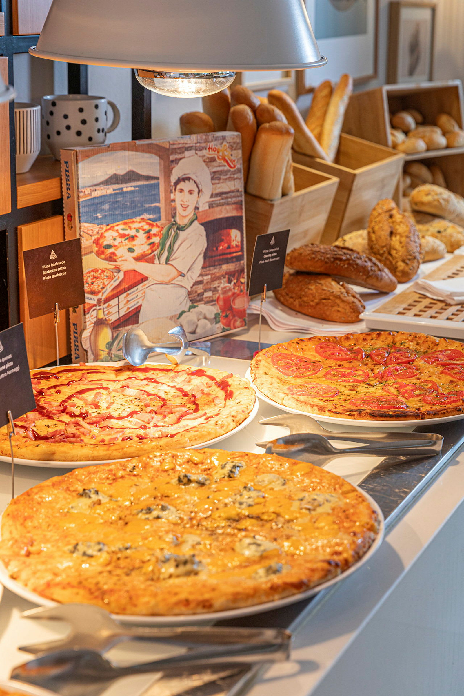 En buffet med forskellige slags pizzaer og brød. (AI-genereret tekst)