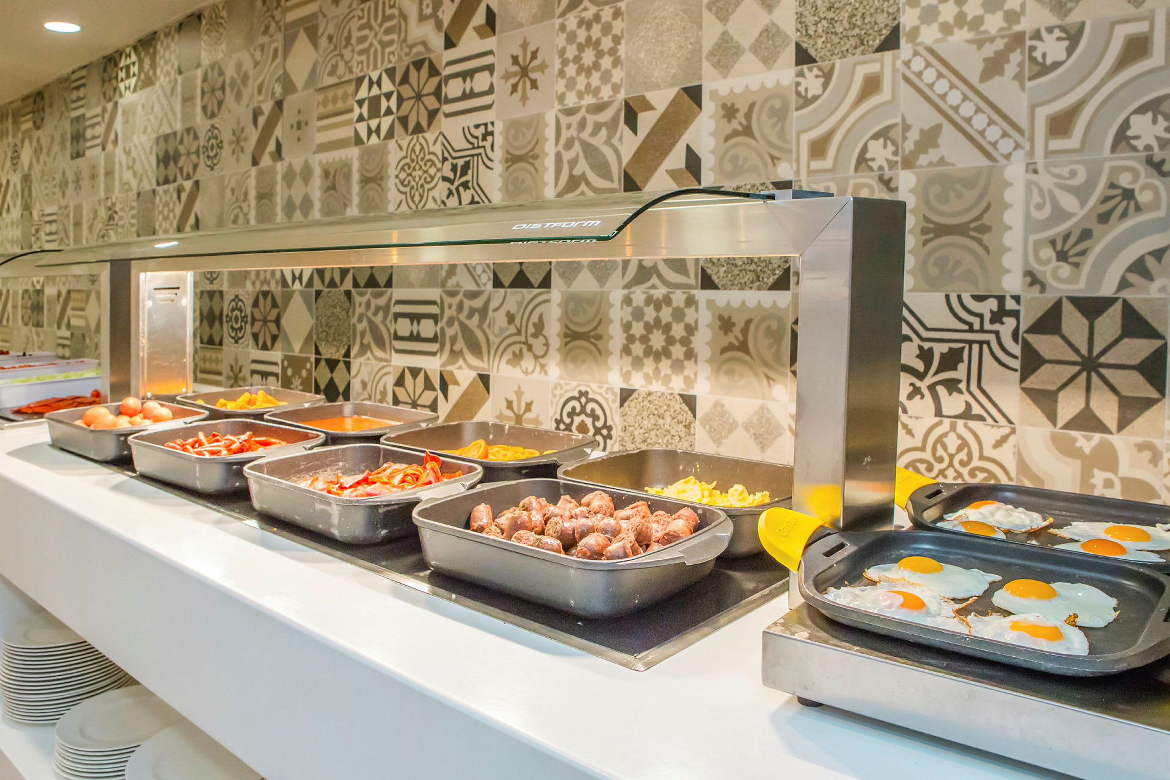 Buffet med forskellige retter, inklusive pølser og æg. (AI-genereret tekst)