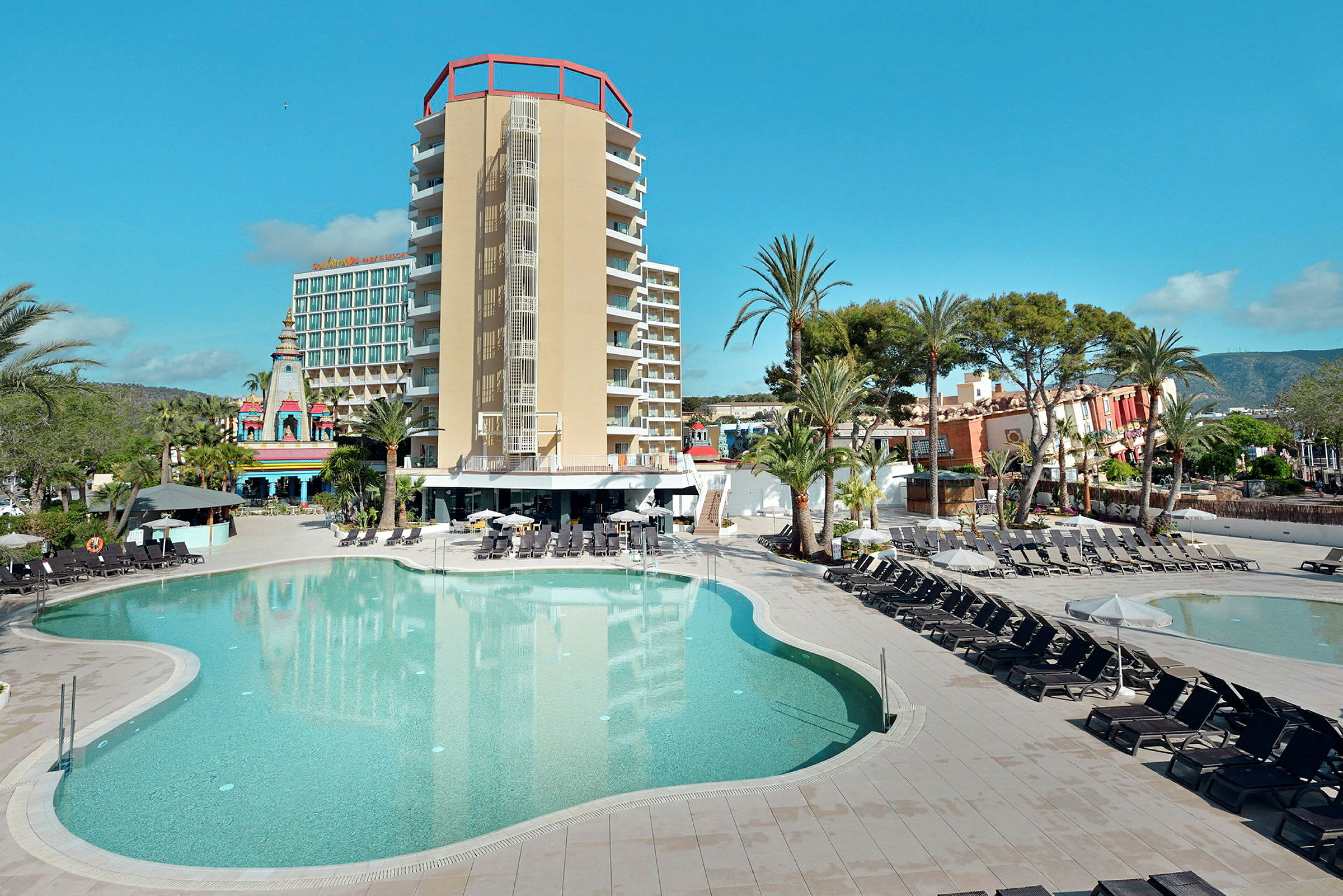 Poolområde med liggestole og en moderne hotelbygning i baggrunden. (AI-genereret tekst)