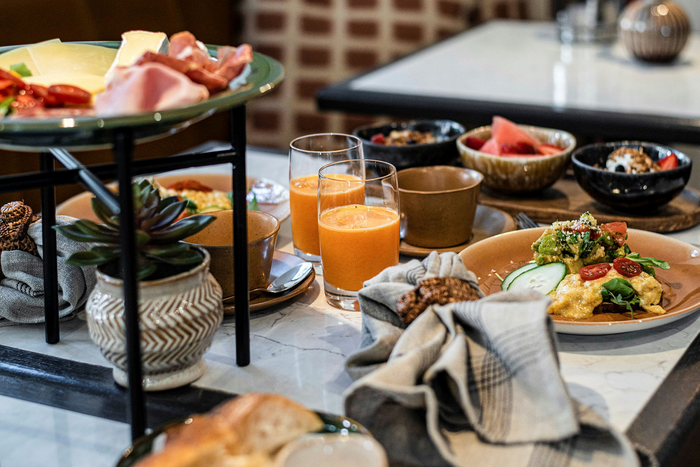 En morgenbuffet med forskellige retter og drikkevarer på et bord. (AI-genereret tekst)