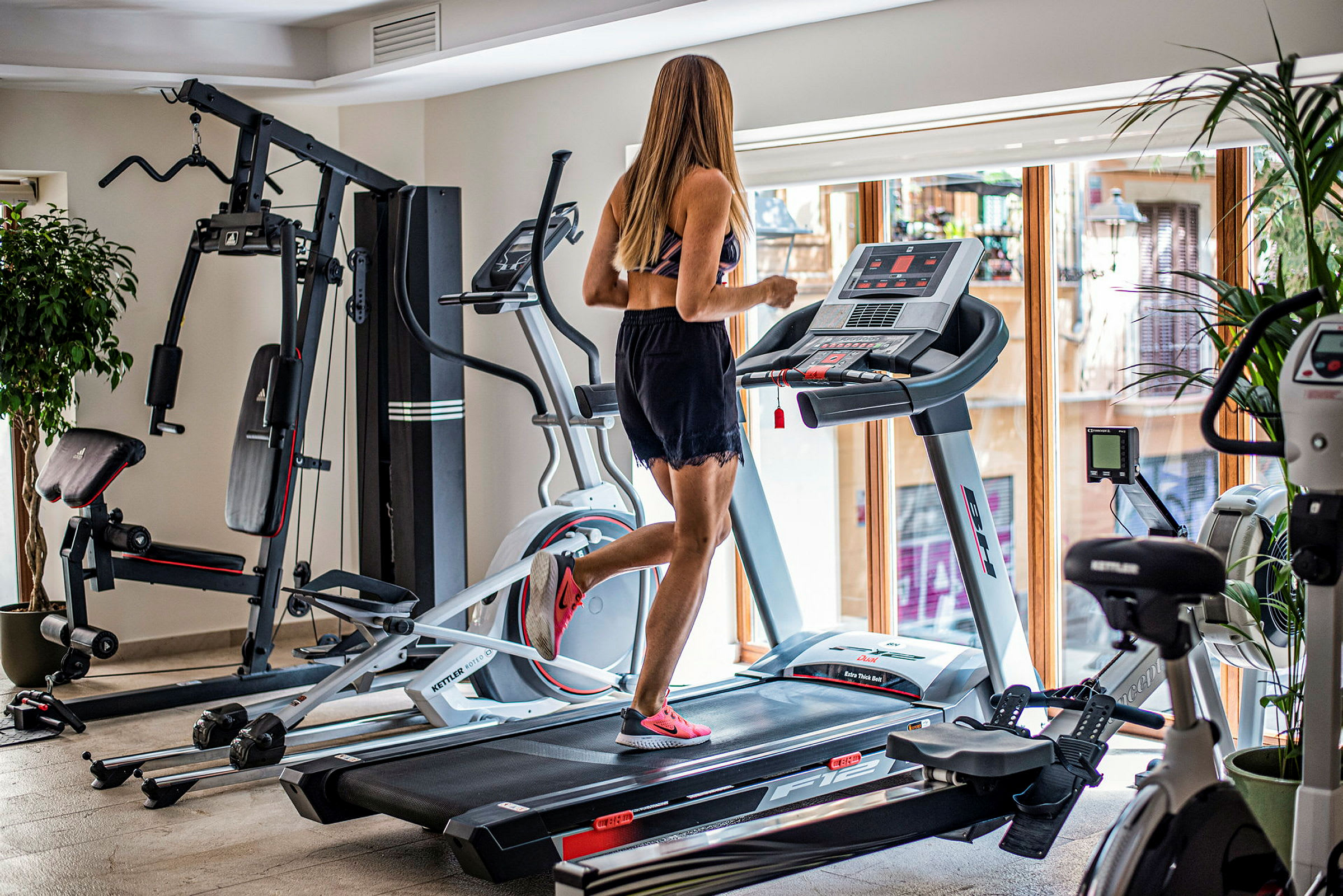 En kvinde løber på et løbebånd i et fitnesscenter. (AI-genereret tekst)