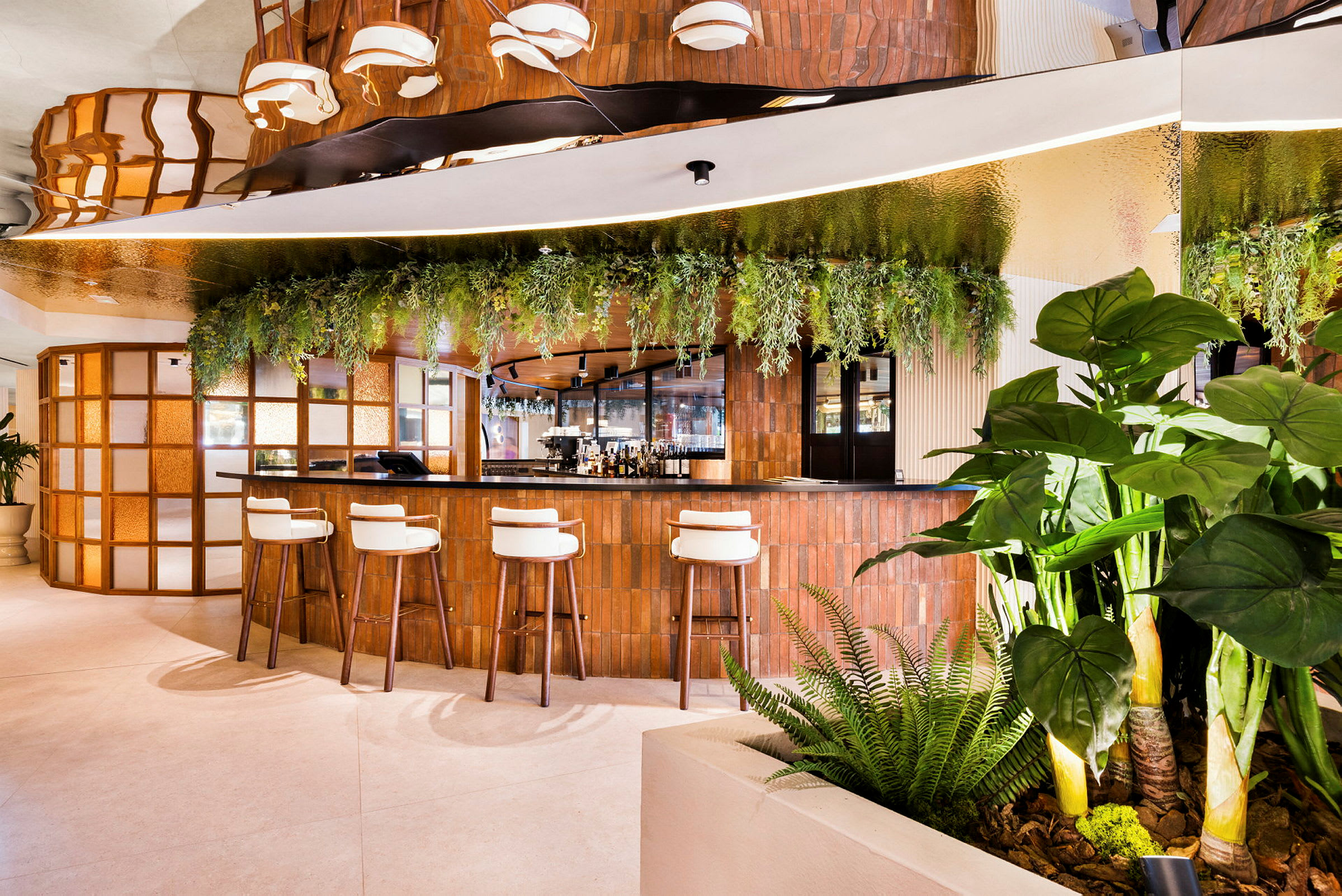 Et moderne caféområde med en bar omgivet af grønne planter og siddepladser. (AI-genereret tekst)