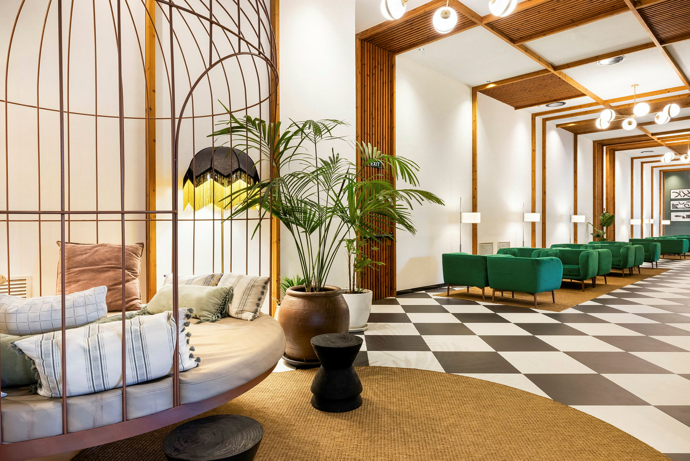 Et moderne indrettet rum med siddepladser, en dekorativ rund sofa med puder og flere grønne planter som dekoration. (AI-genereret tekst)