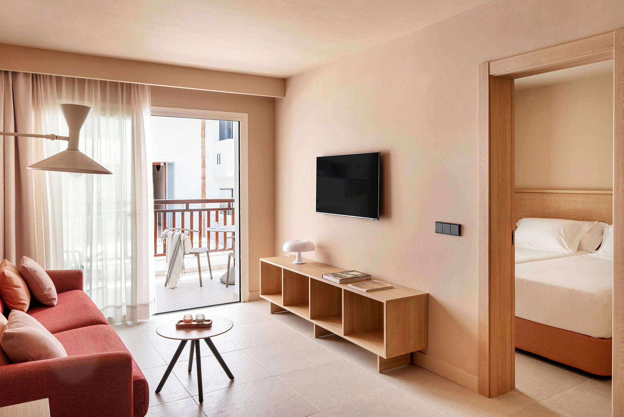 En lys og moderne hotelsuite med stue og tilhørende soveværelse. (AI-genereret tekst)