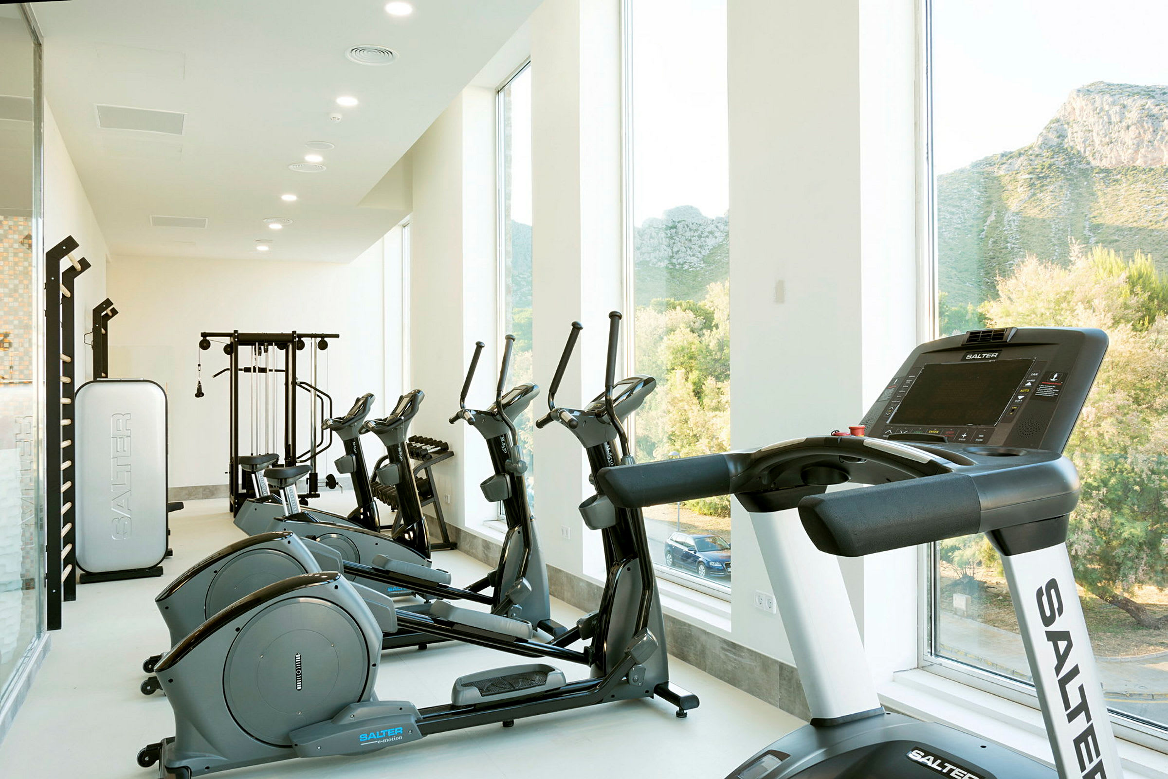 Et fitnesscenter med træningsmaskiner, herunder løbebånd og motionscykler. (AI-genereret tekst)