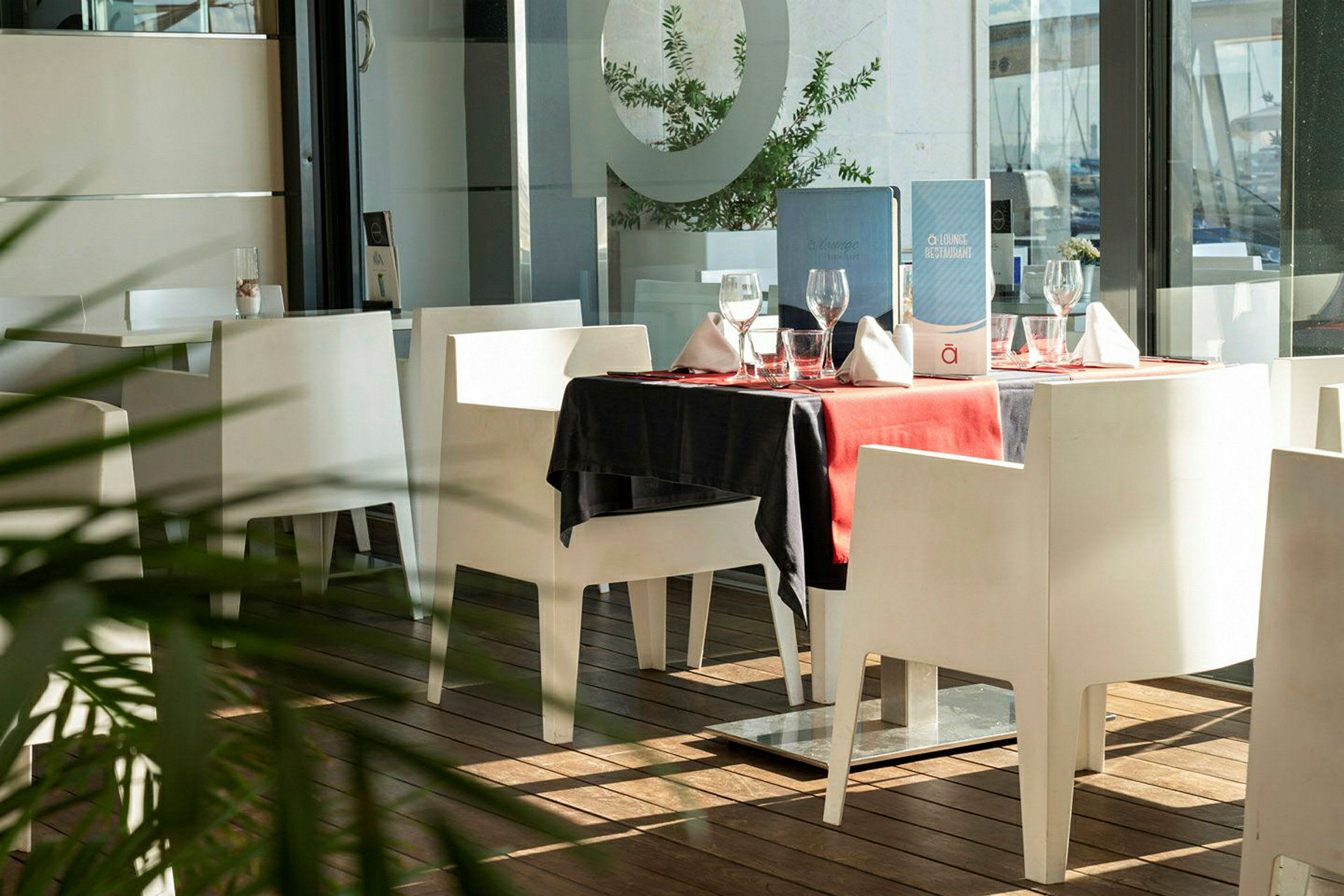 Et bord i en restaurant med hvid indretning og rød dug. (AI-genereret tekst)