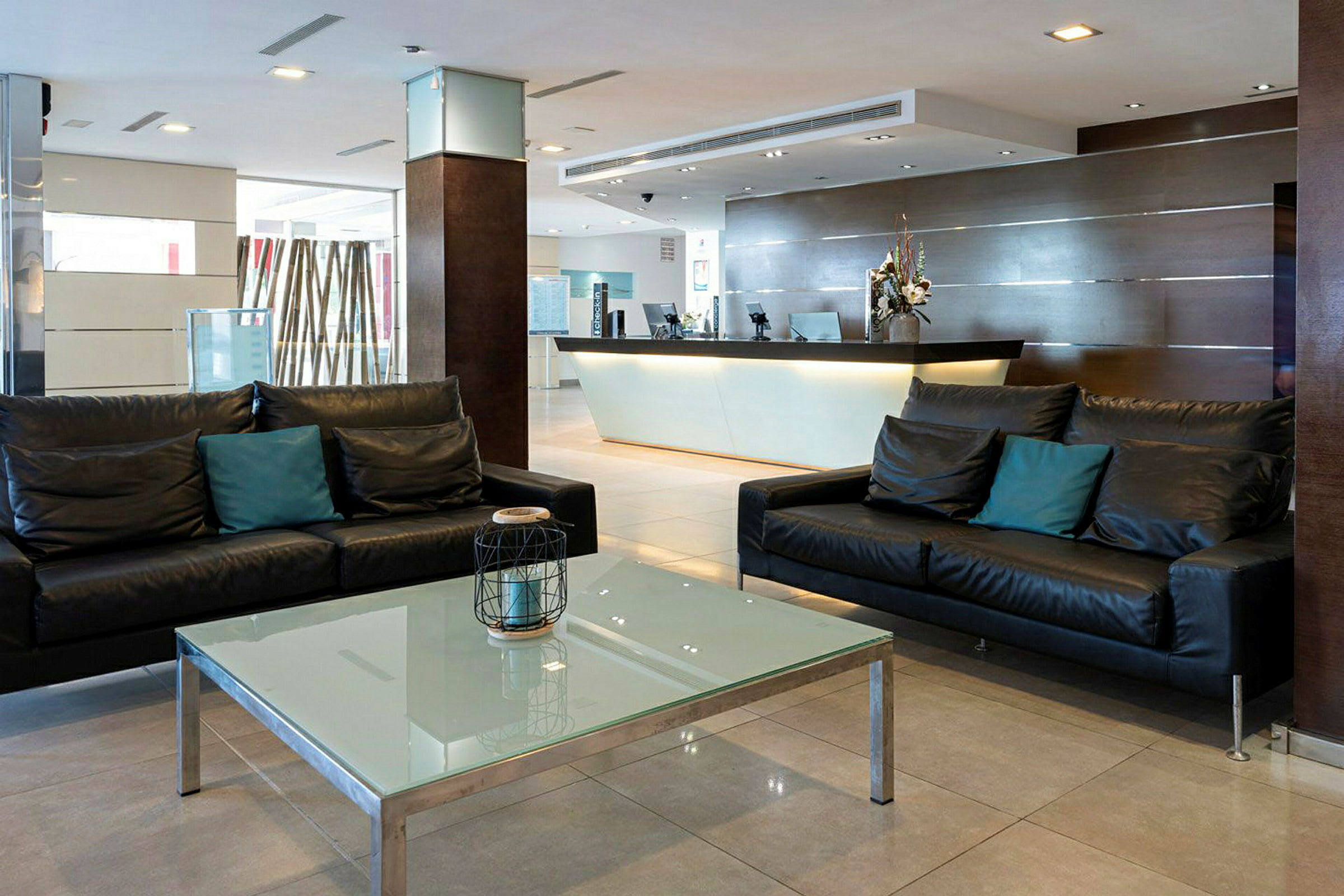 Hotellobby med sofaer og receptionsdisk. (AI-genereret tekst)