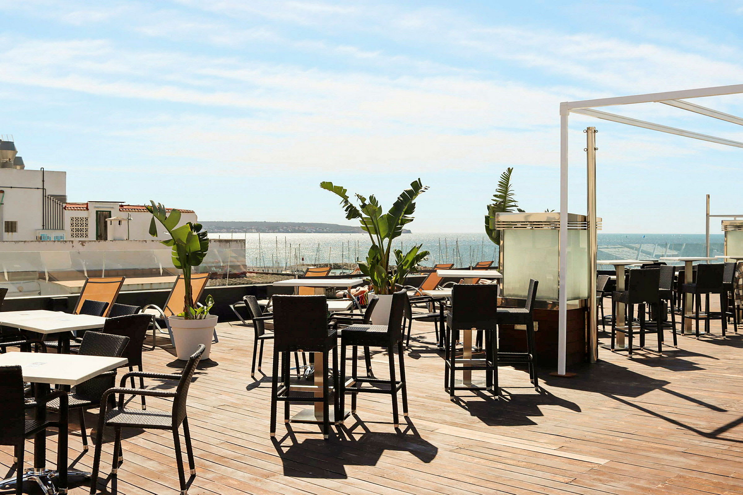 Terrasse med udendørsmøbler og udsigt over havet. (AI-genereret tekst)