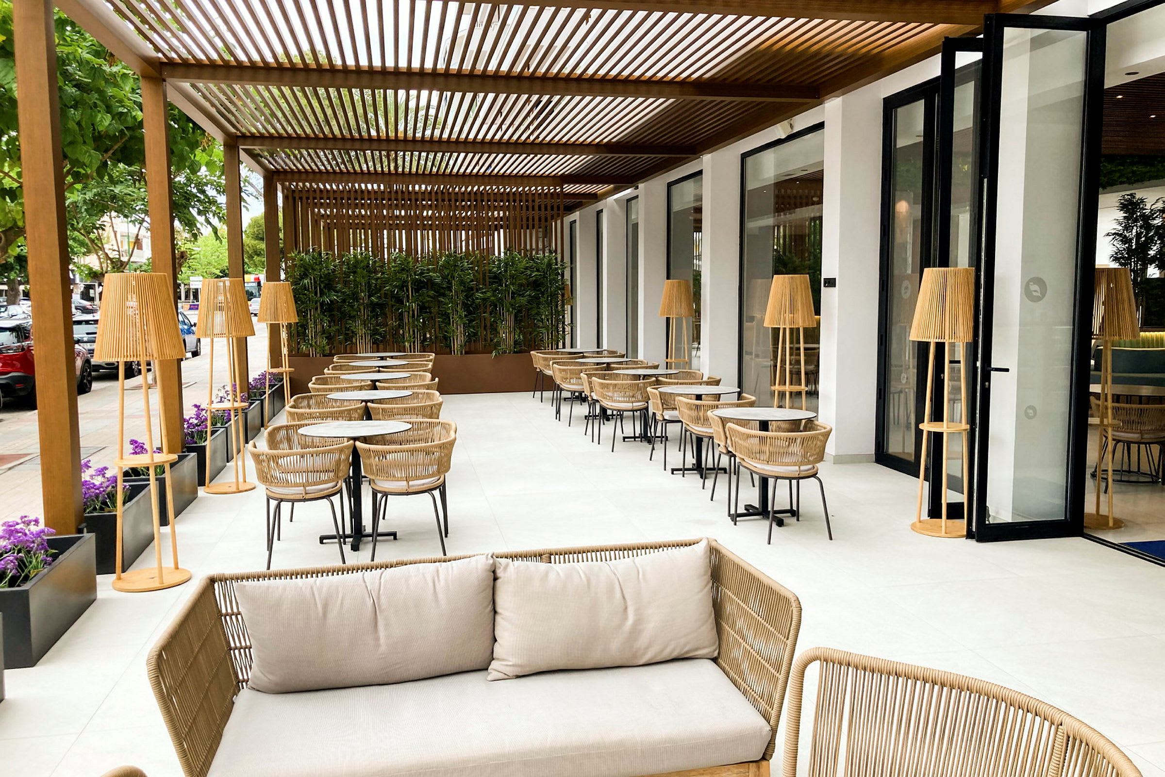 Udendørs terrasse med siddepladser, borde og kurvemøbler. (AI-genereret tekst)