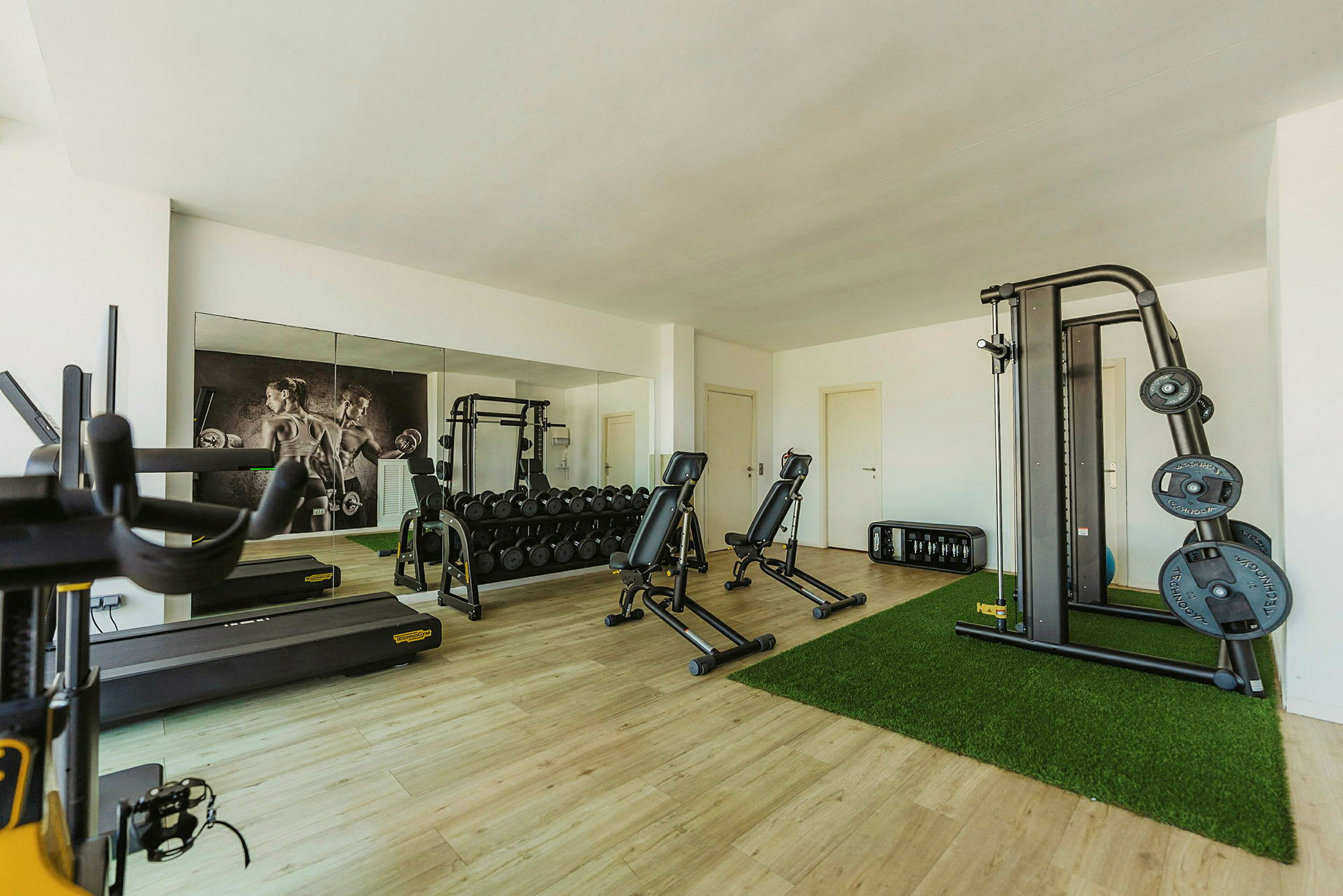 Et træningsrum med forskelligt fitnessudstyr såsom løbebånd, vægte og træningsmaskiner. (AI-genereret tekst)