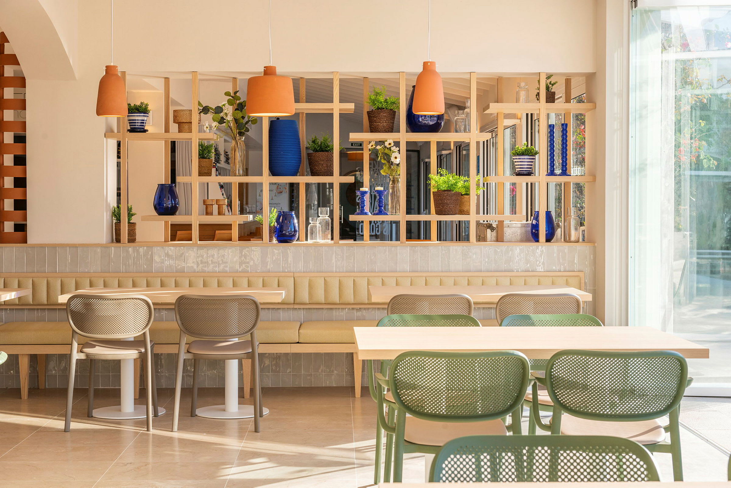 En lys og moderne café med stilfulde møbler og grønne planter. (AI-genereret tekst)