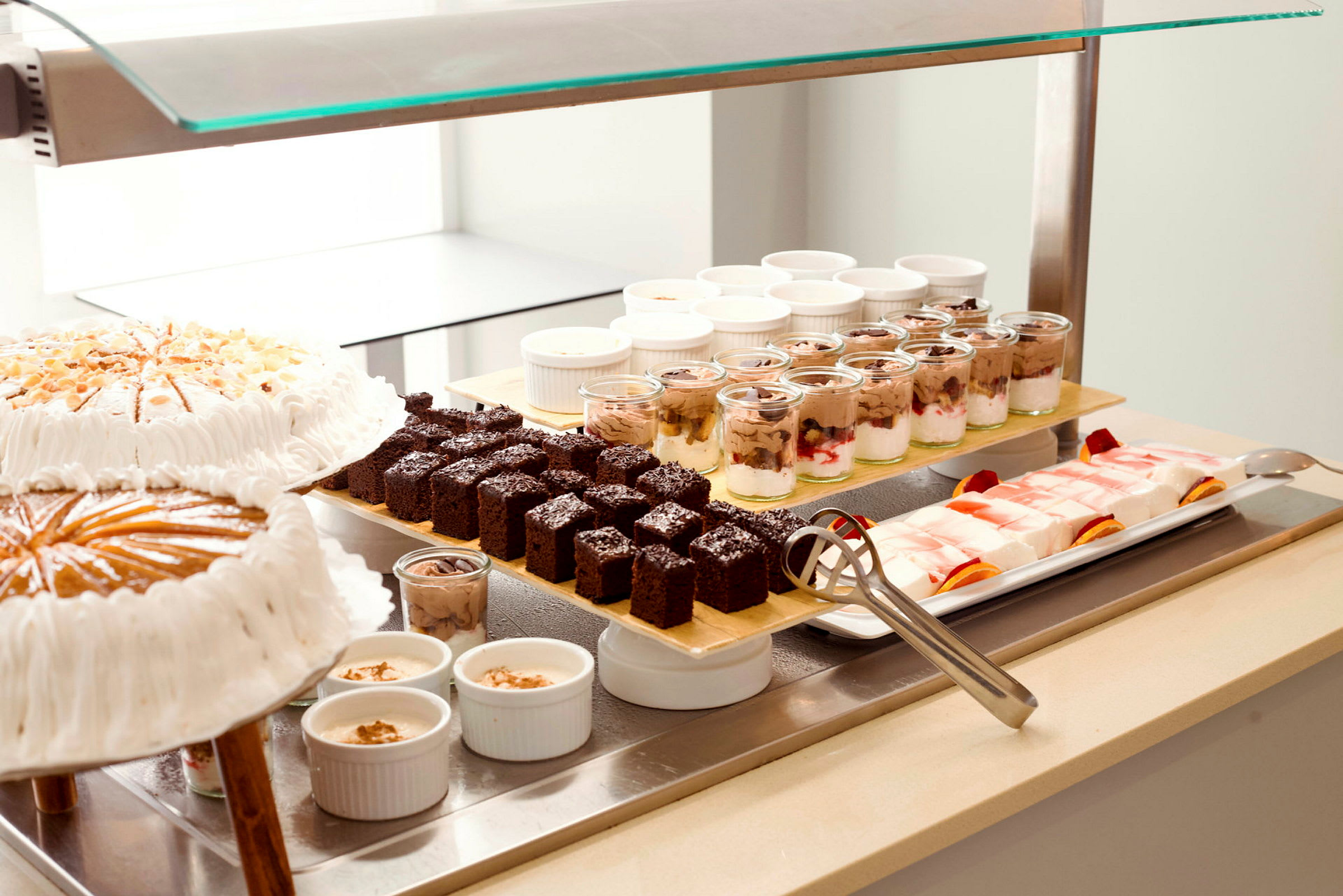 Billede af en buffet med forskellige desserter, inklusive kager, chokoladekager, pudding og gelé. (AI-genereret tekst)