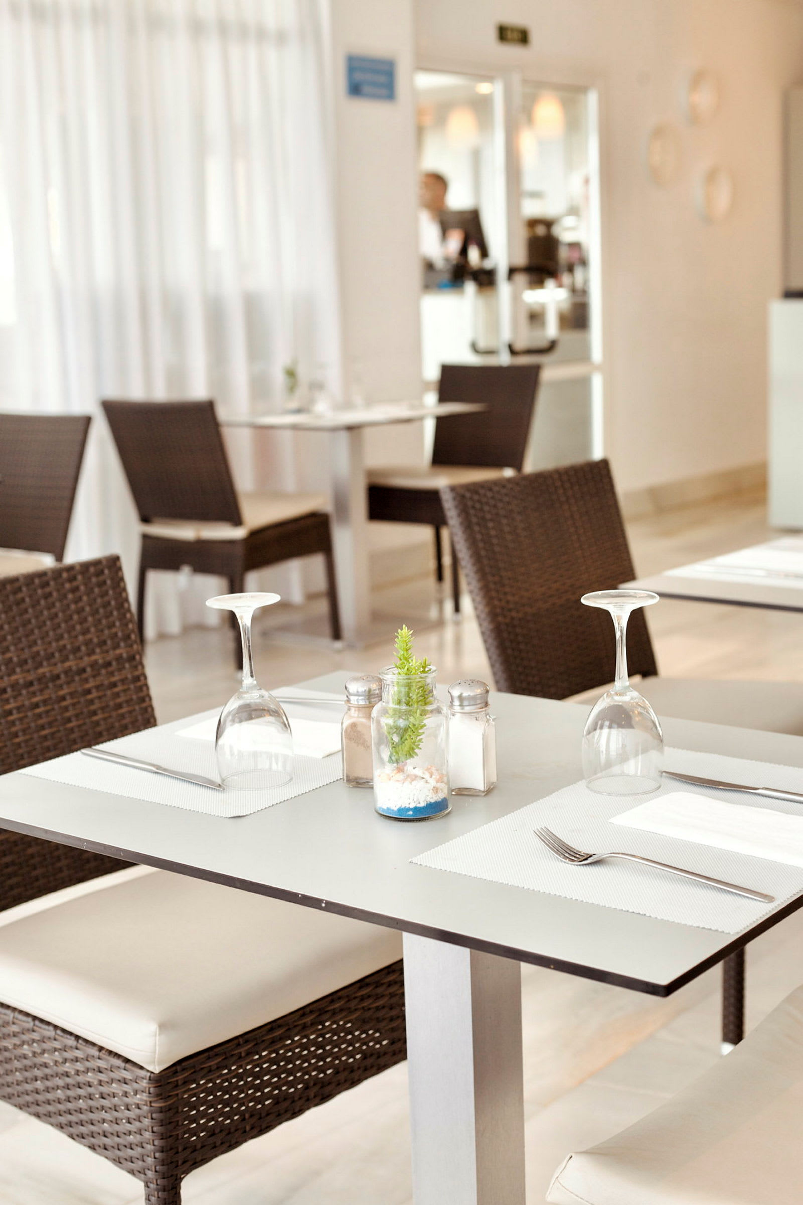 Et dækket bord med stole i en restaurant. (AI-genereret tekst)