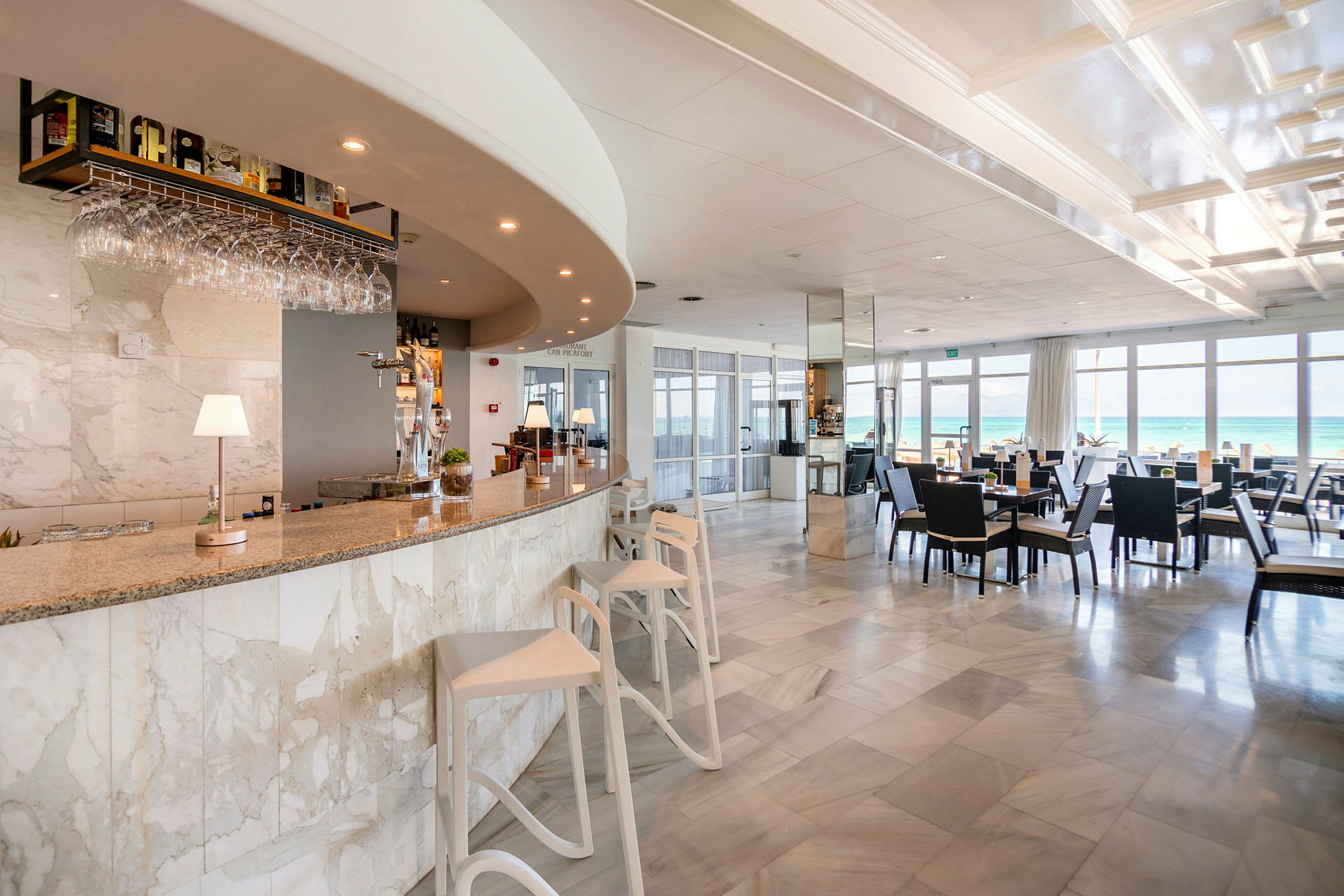 En lys bar og restaurant med udsigt over havet. (AI-genereret tekst)