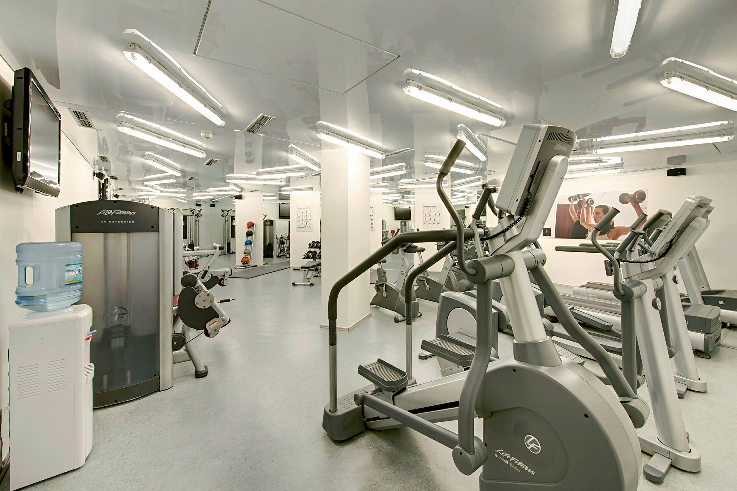Indendørs fitnesscenter med træningsmaskiner og frie vægte. (AI-genereret tekst)