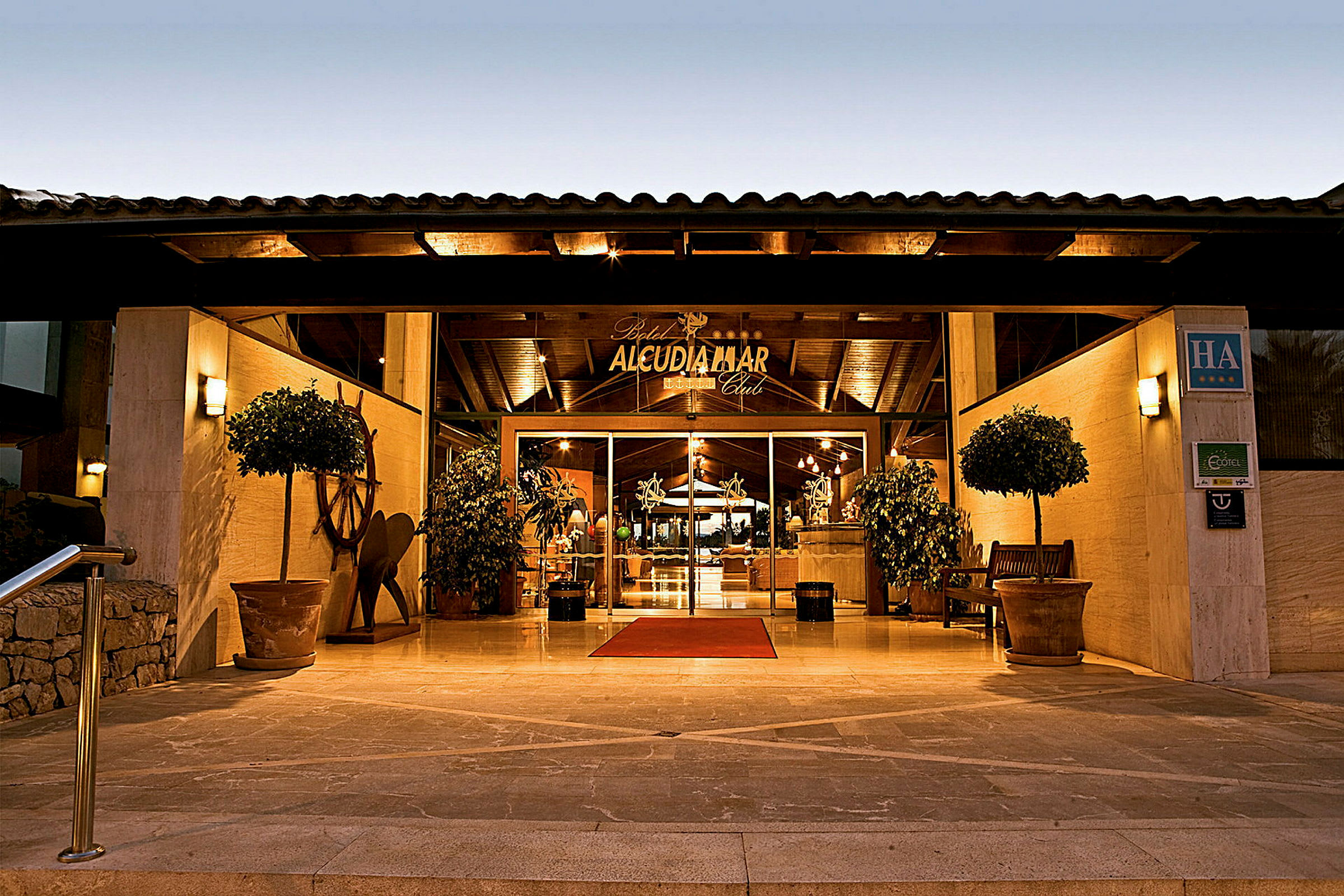 Indgang til Alcudia Mar Club Hotel om aftenen. (AI-genereret tekst)