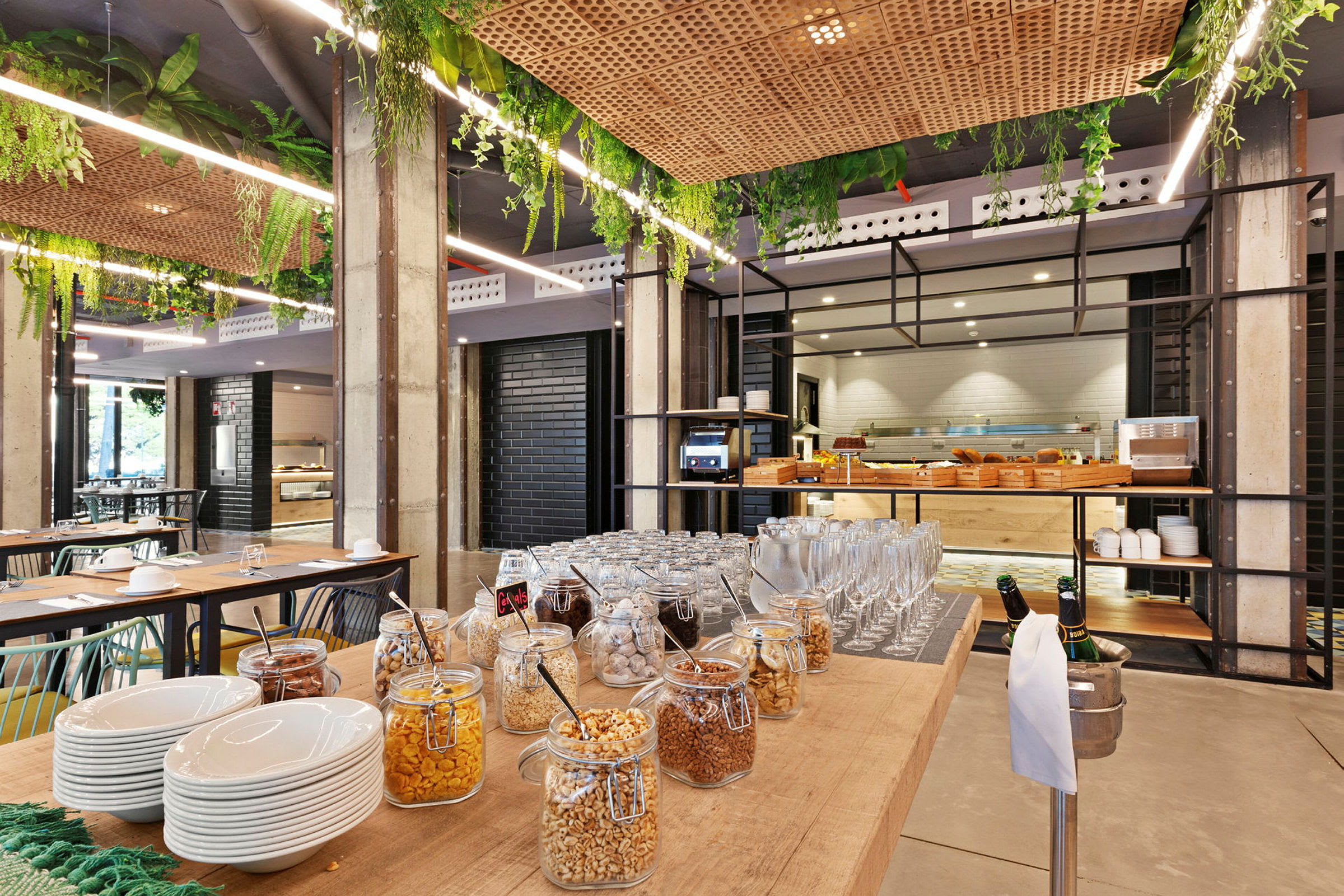 En buffet med glasbeholdere fyldt med forskellige slags morgenmadsprodukter og serveringsskåle i et moderne restaurantmiljø. (AI-genereret tekst)