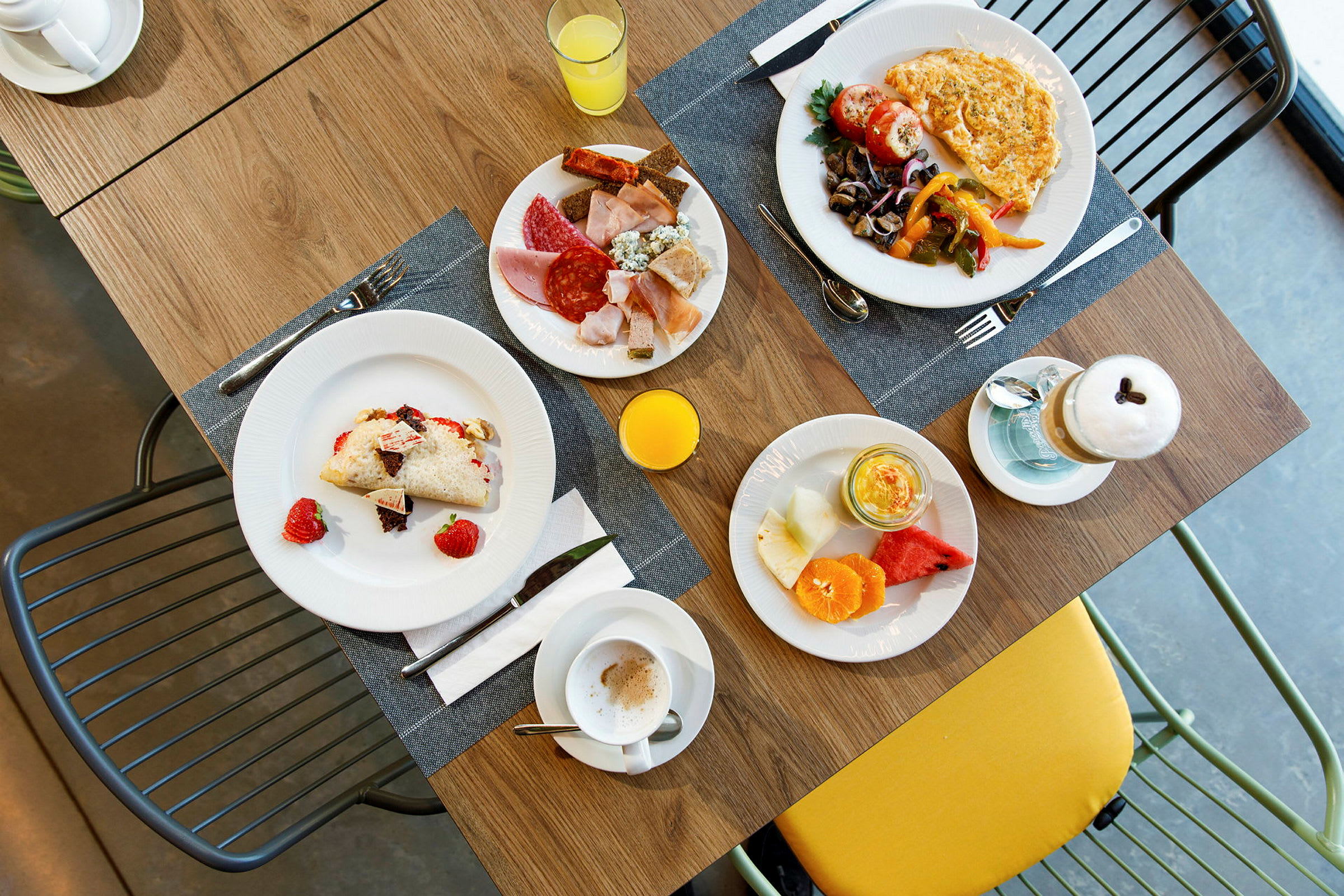 En morgenmad som er serveret på et bord med flere forskellige retter og drikkevarer. (AI-genereret tekst)