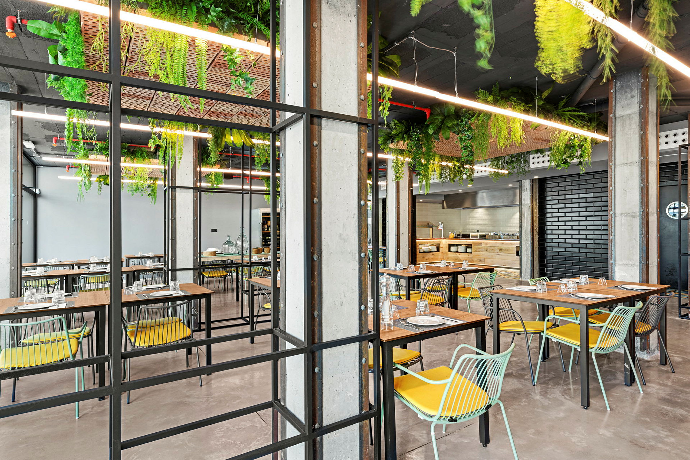 En moderne restaurant med borde, stole og planter hængende fra loftet. (AI-genereret tekst)