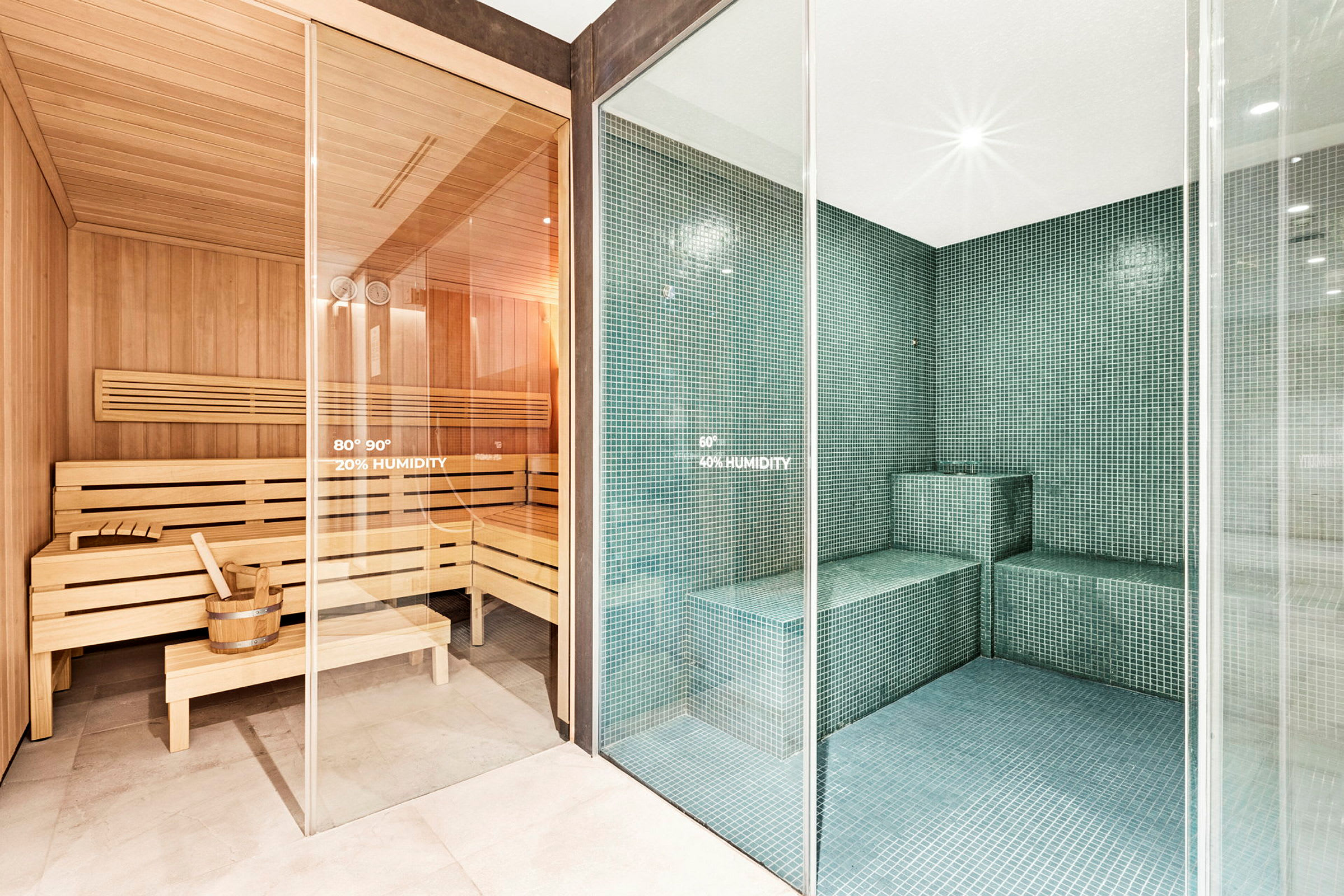 Billede af en traditionel sauna med træpaneler ved siden af et moderne dampbad med flisebelagte overflader. (AI-genereret tekst)