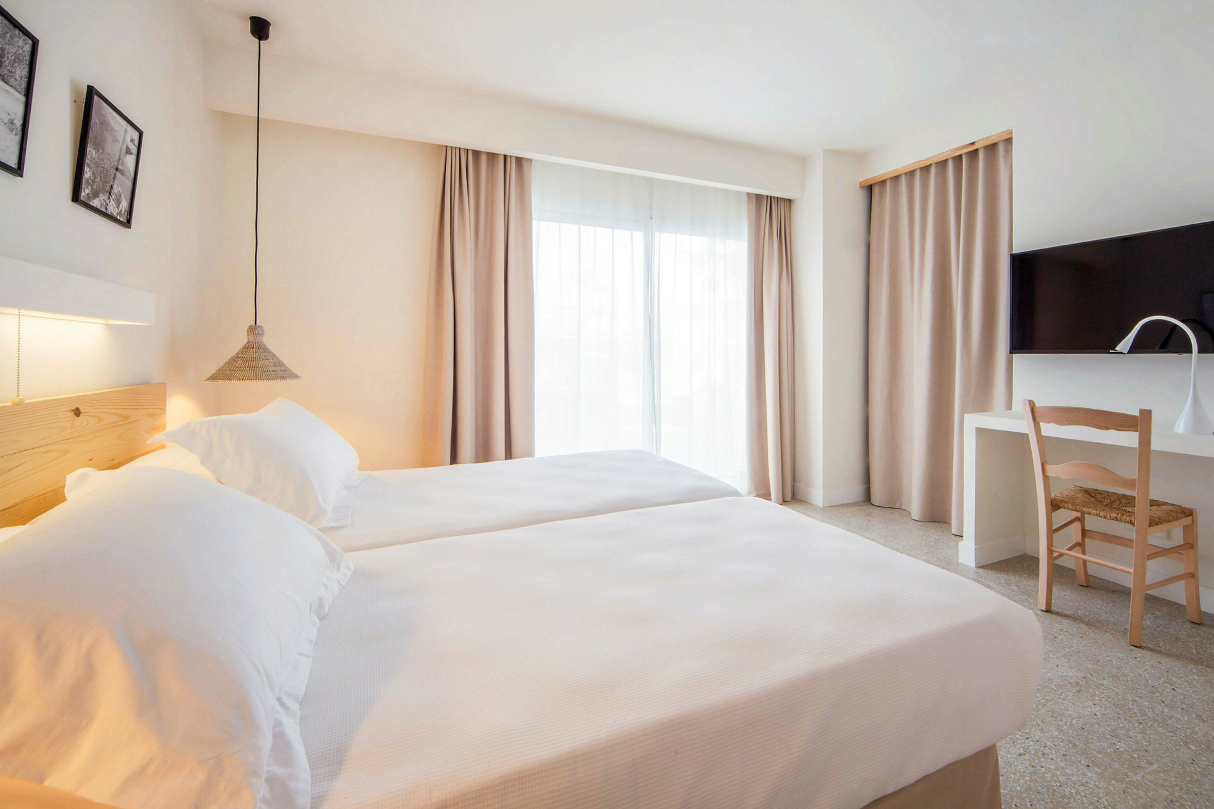 Moderne hotelværelse med to enkeltsenge, skrivebord og TV. (AI-genereret tekst)