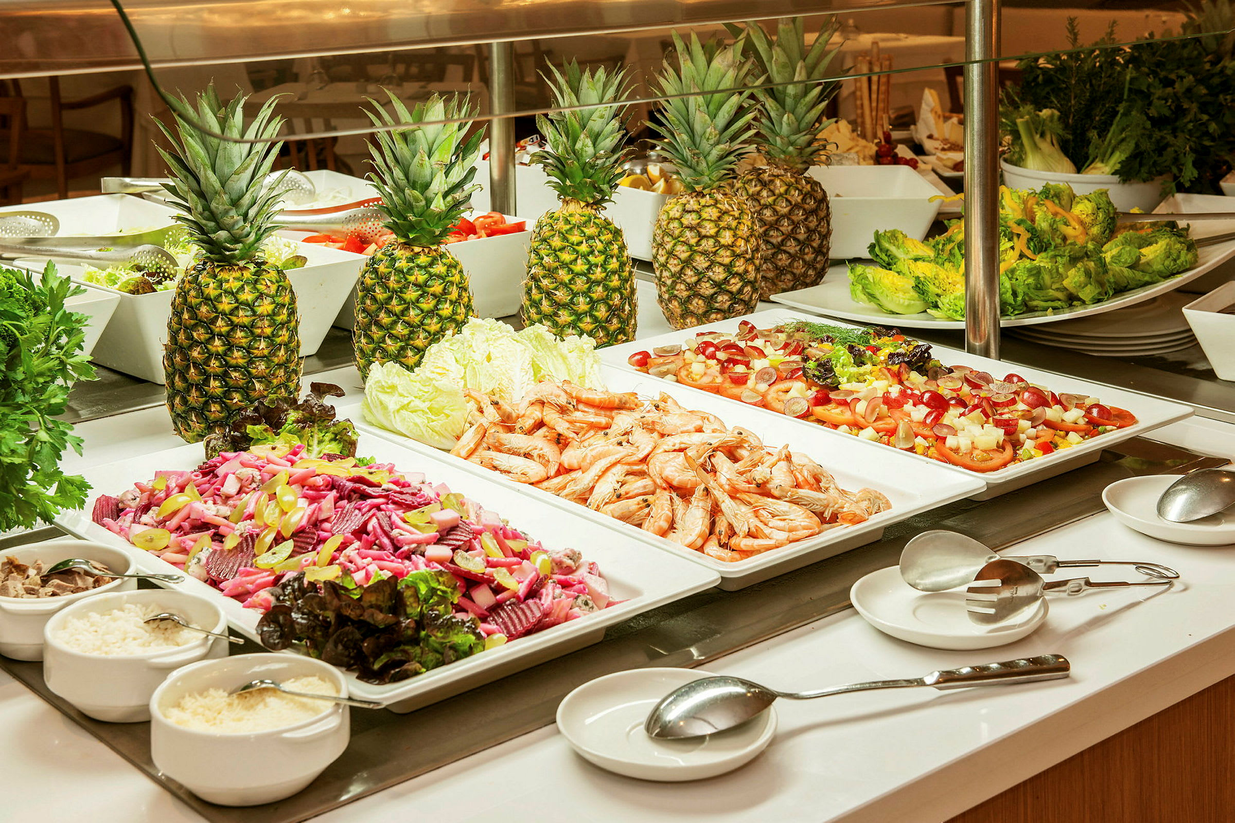 Buffetbord med salat, rejer og ananas. (AI-genereret tekst)