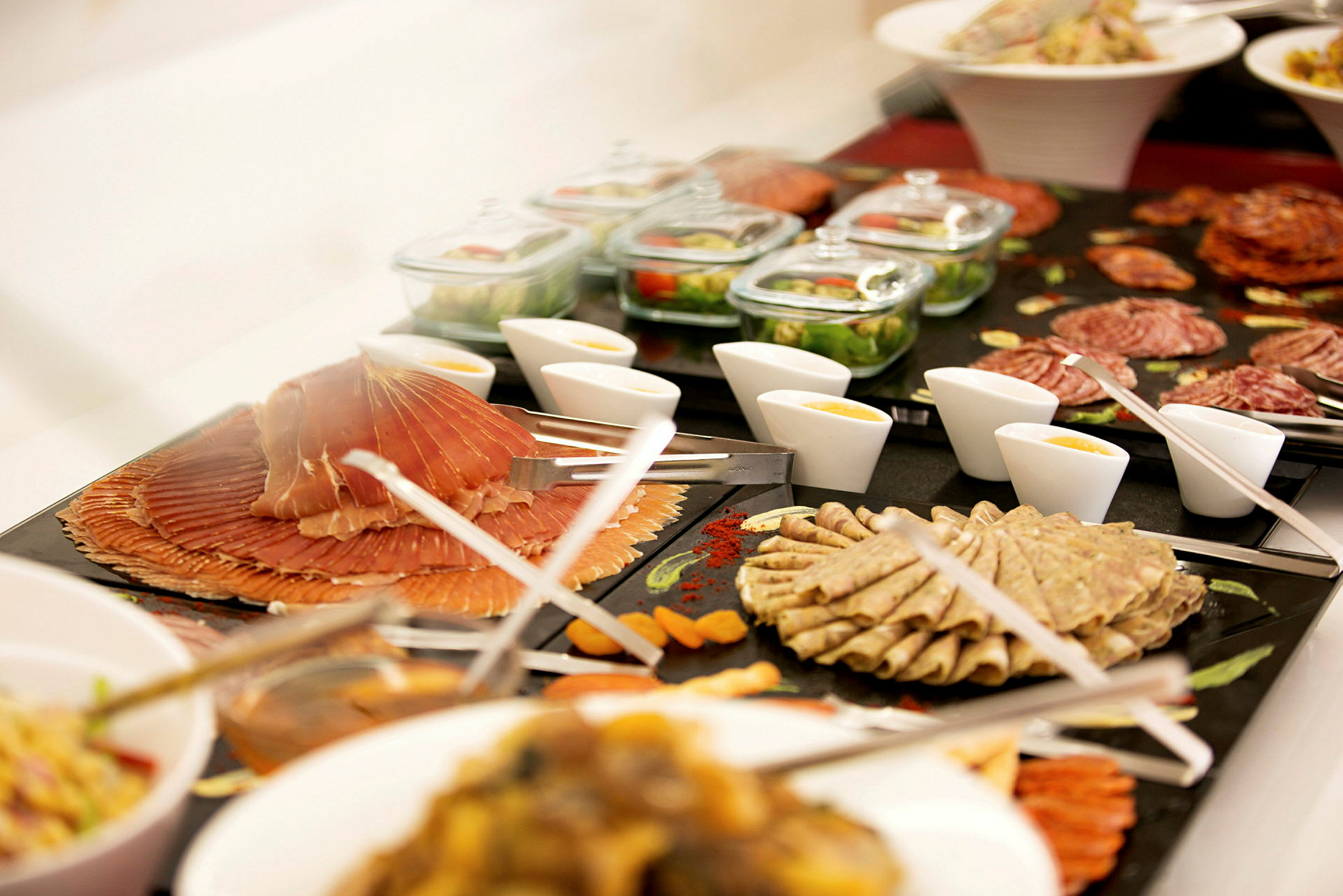 En buffet med forskellige pålæg, salater, saucer og tilbehør arrangeret på skåle og fade. (AI-genereret tekst)