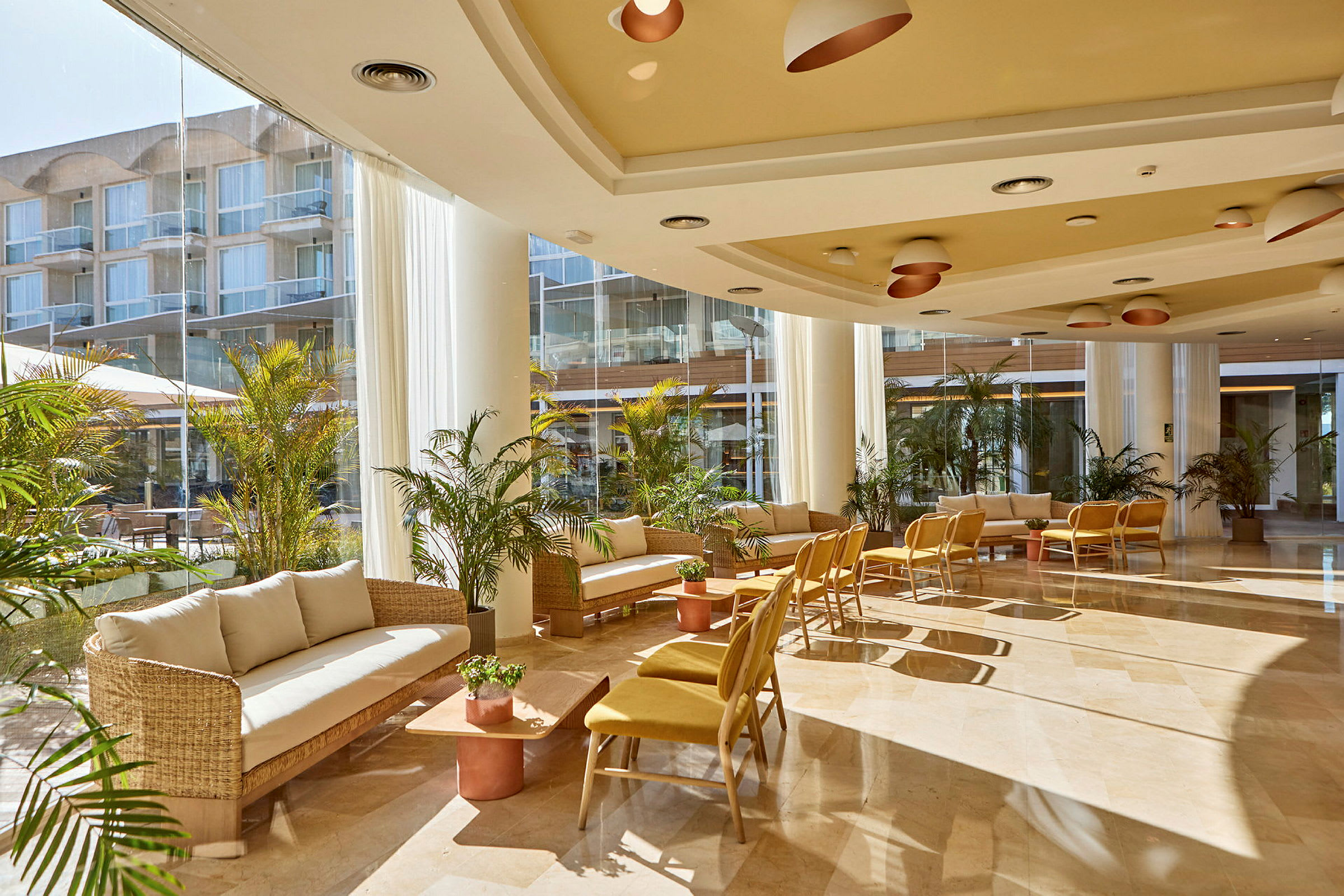 Interiør af en lys og moderne hotellobby med siddeområder og planter. (AI-genereret tekst)