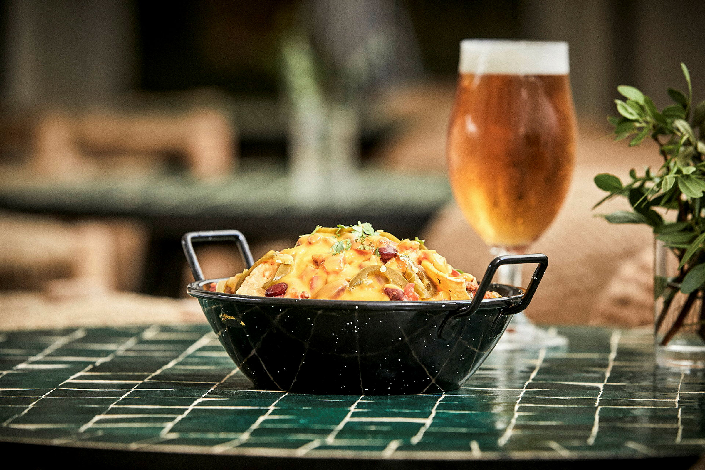 En skål med mad serveret på et bord ved siden af et glas med drikke. (AI-genereret tekst)