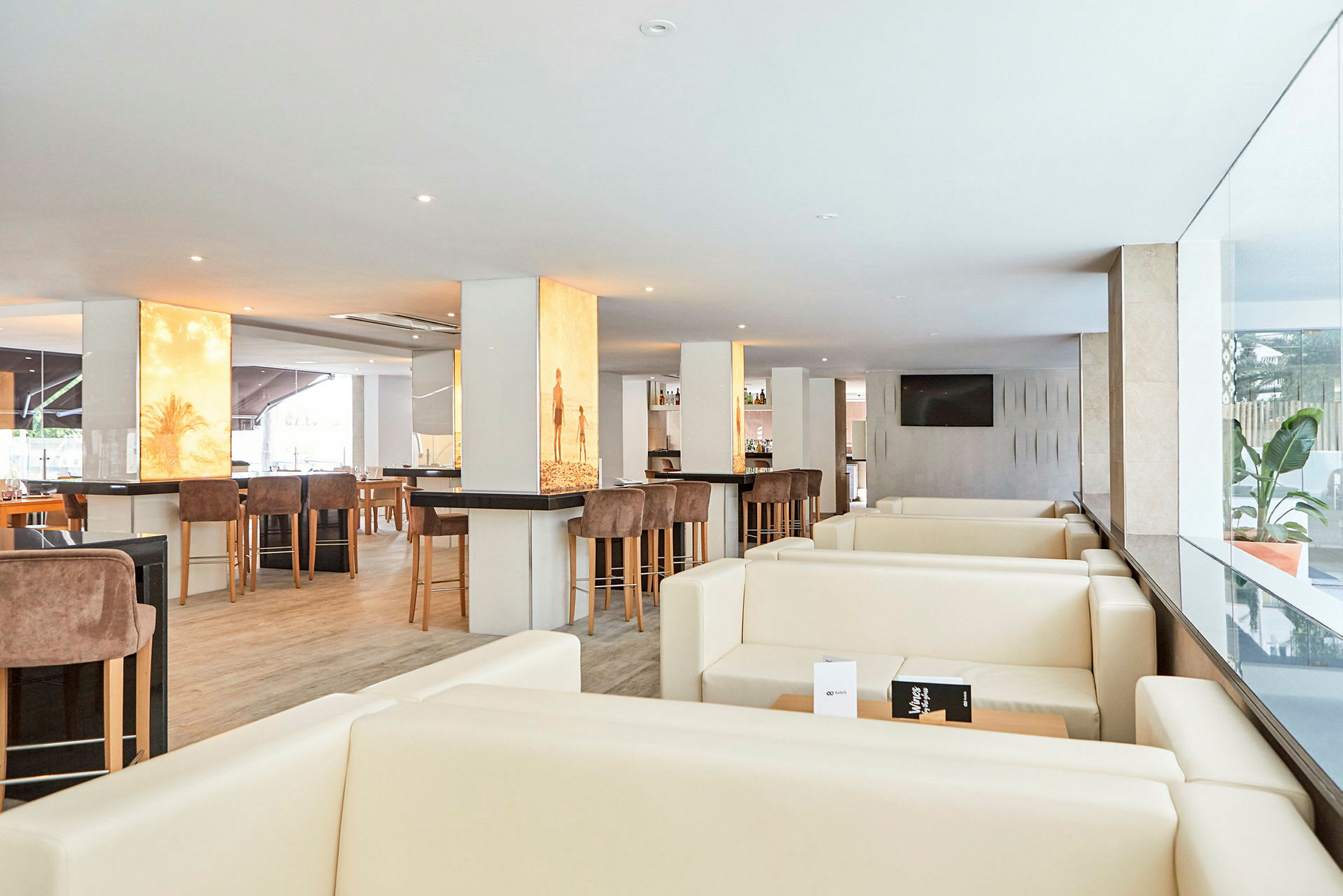 Billede af en moderne restaurantlounge med lyse møbler og barmøbler. (AI-genereret tekst)