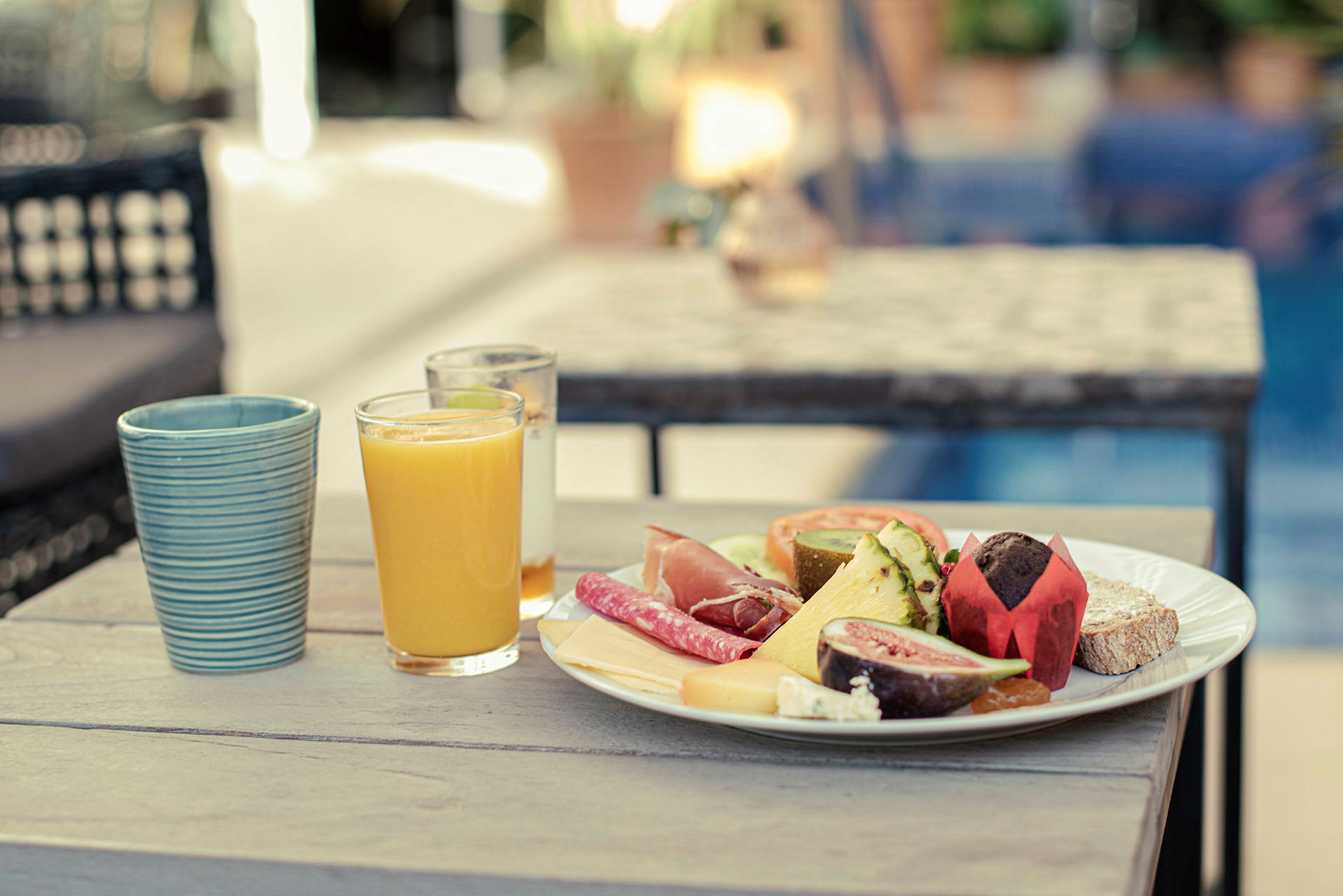 Morgenbord med et glas appelsinjuice og en tallerken fyldt med forskellige madvarer. (AI-genereret tekst)