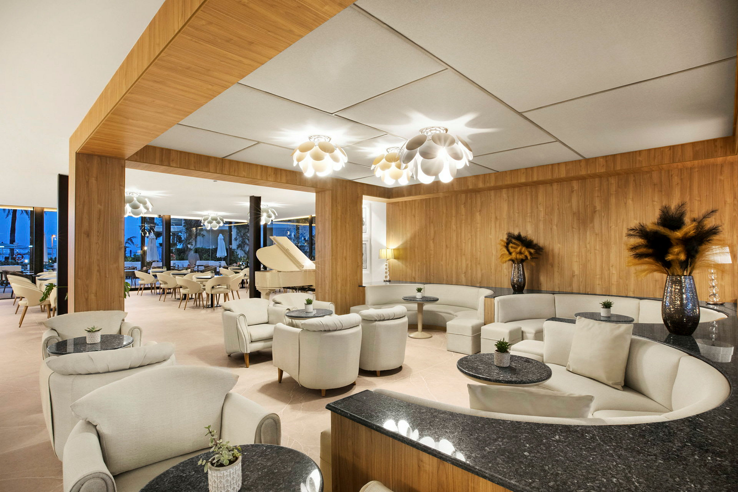 En elegant hotellobby med sofagrupper, små borde og et hvidt flygel. (AI-genereret tekst)