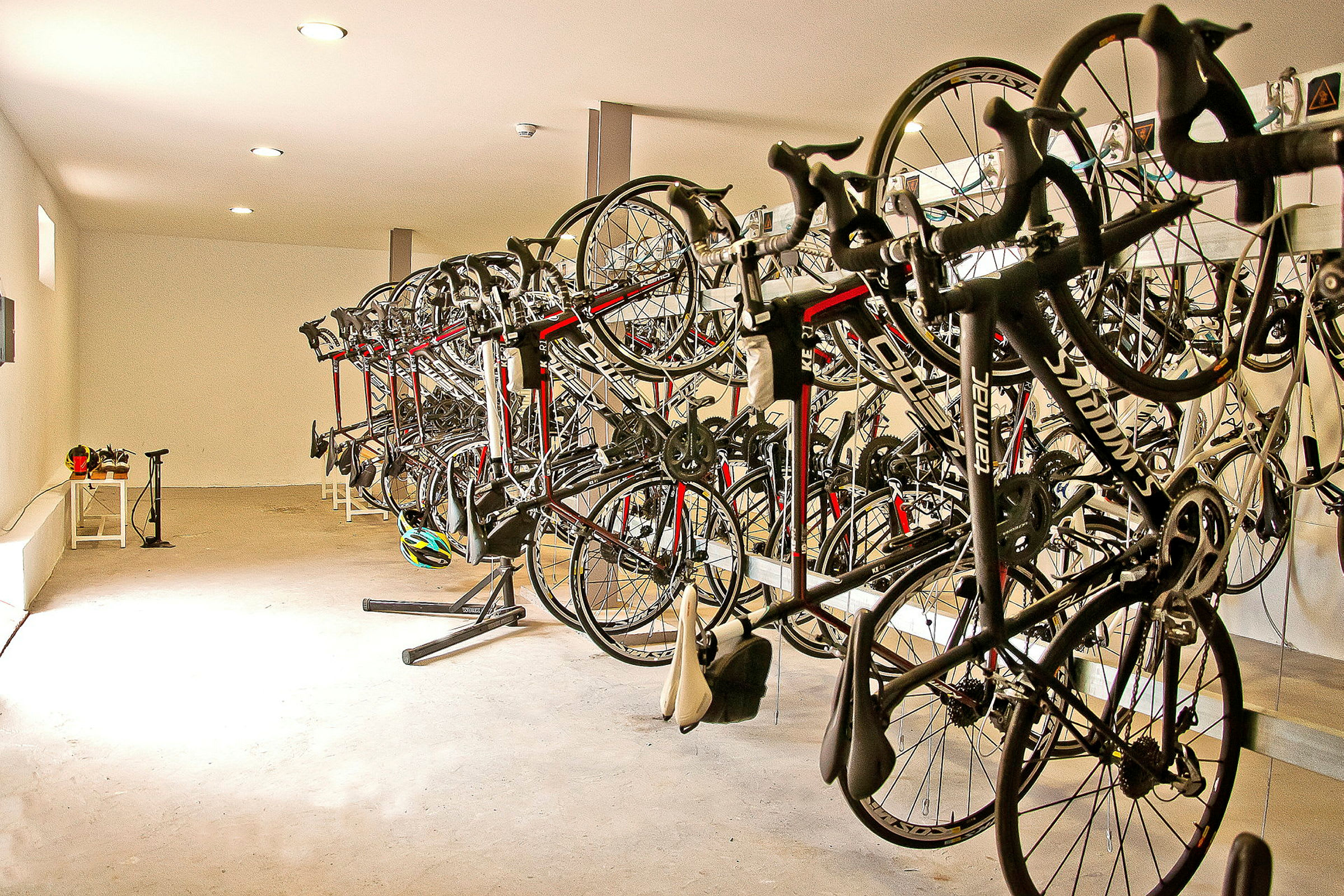 Billede af et rum med flere cykler, der hænger side om side på stativer. (AI-genereret tekst)