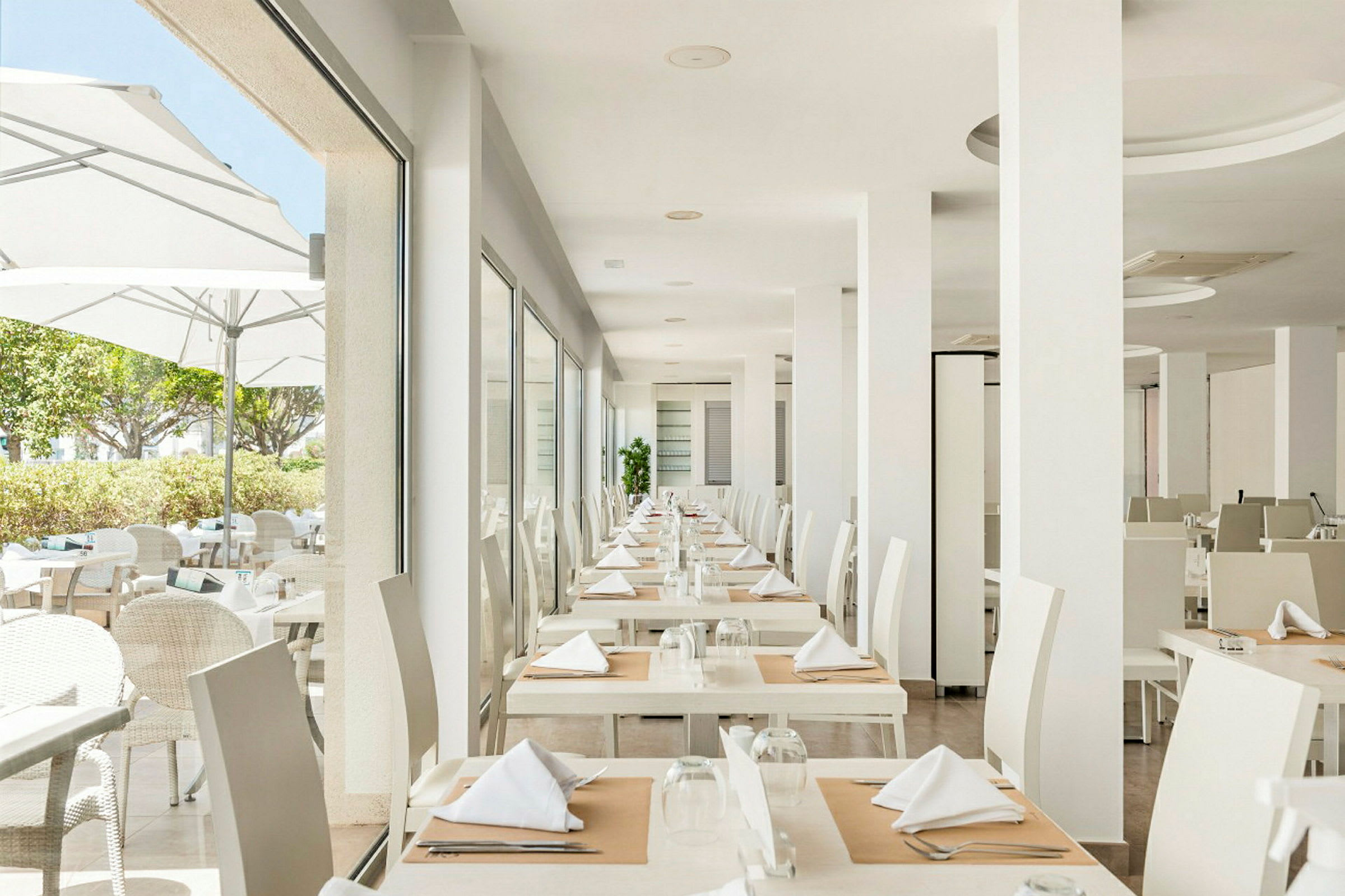 En moderne og lys restaurant med dækkede borde i en organisering. (AI-genereret tekst)