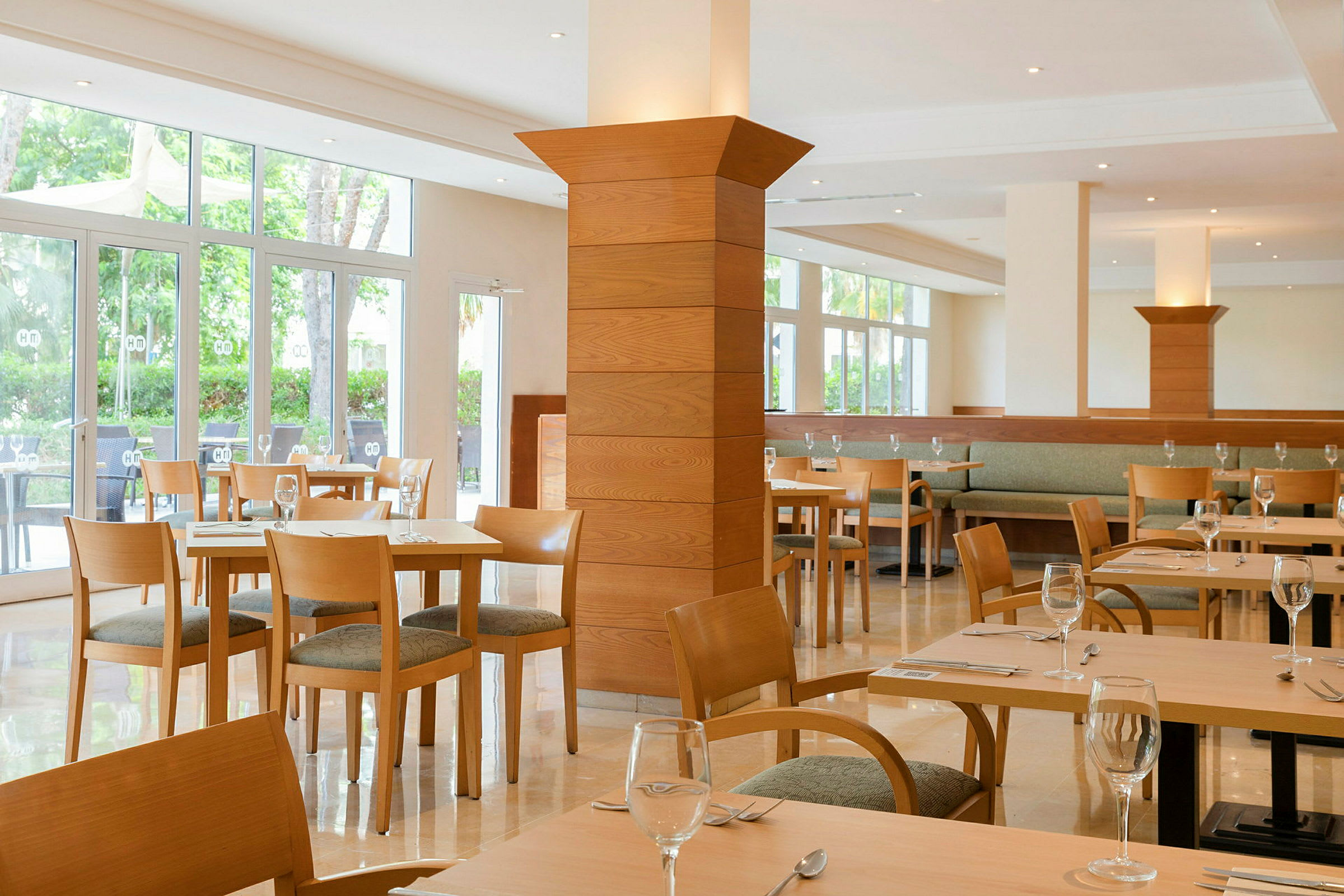 Lyse restaurantmøbler med glasvægge og trædetaljer. (AI-genereret tekst)