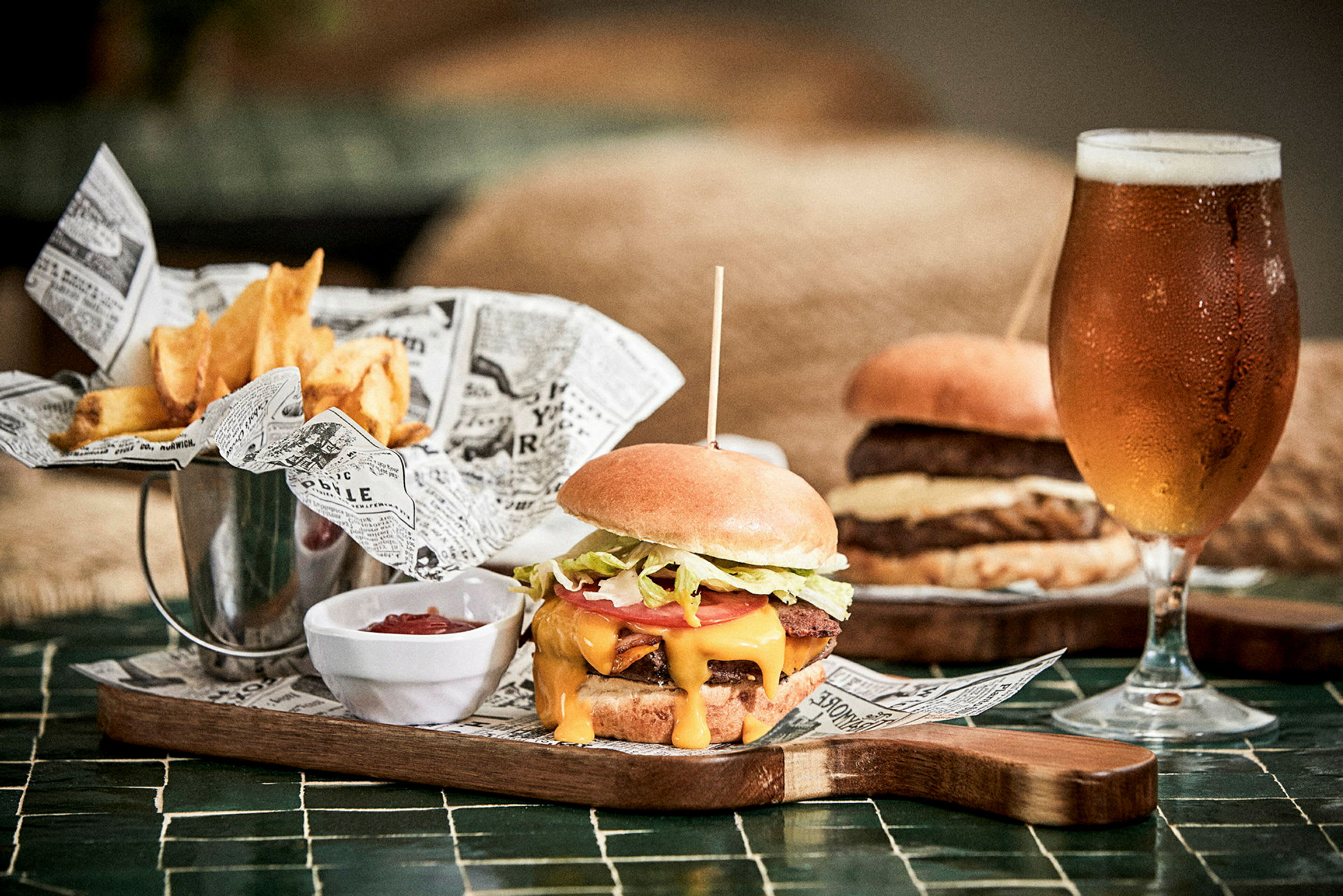 Billede af en burgerret med pommes frites, ketchup og et glas øl. (AI-genereret tekst)