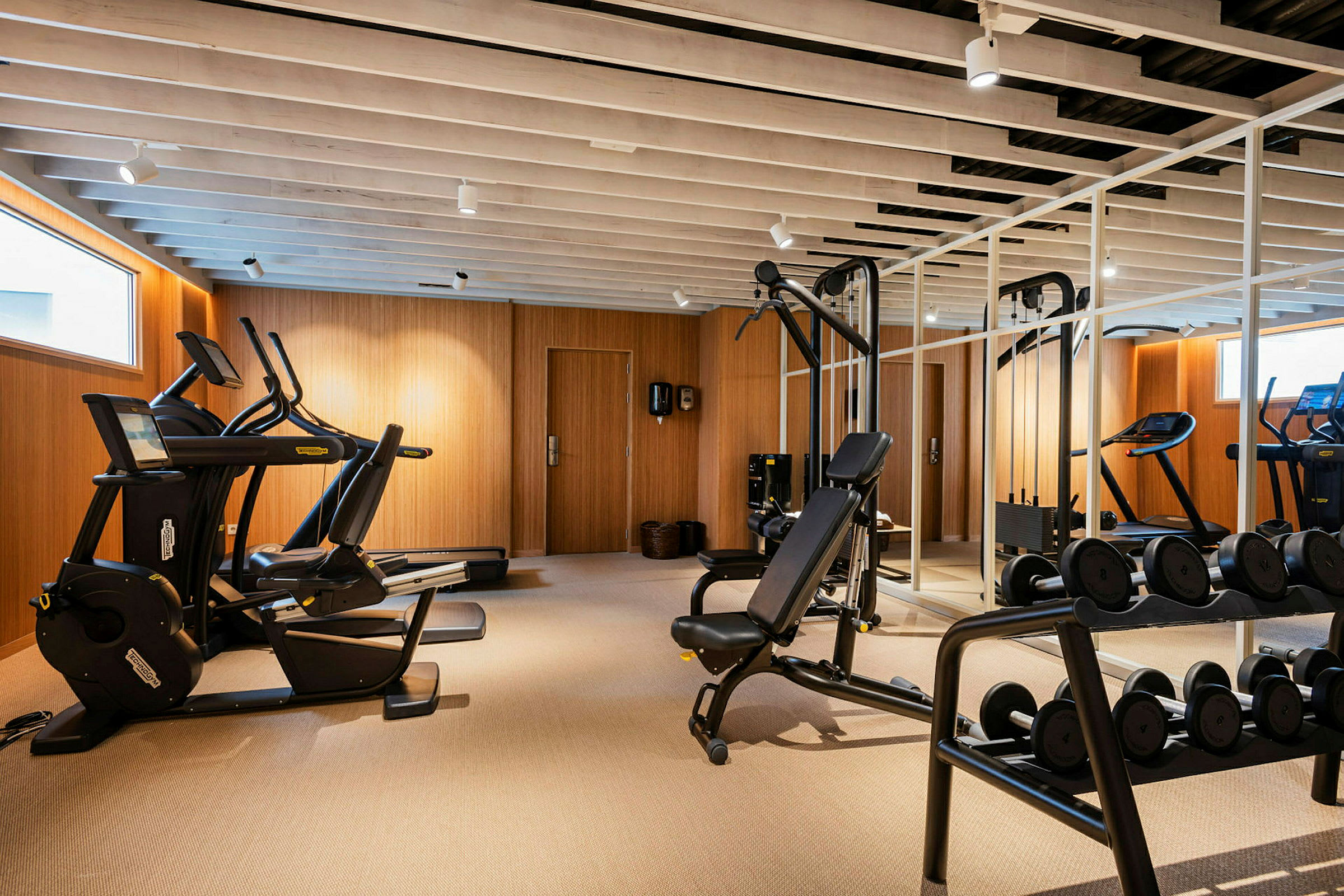 Et moderne fitnesscenter med træningsmaskiner og frie vægte. (AI-genereret tekst)