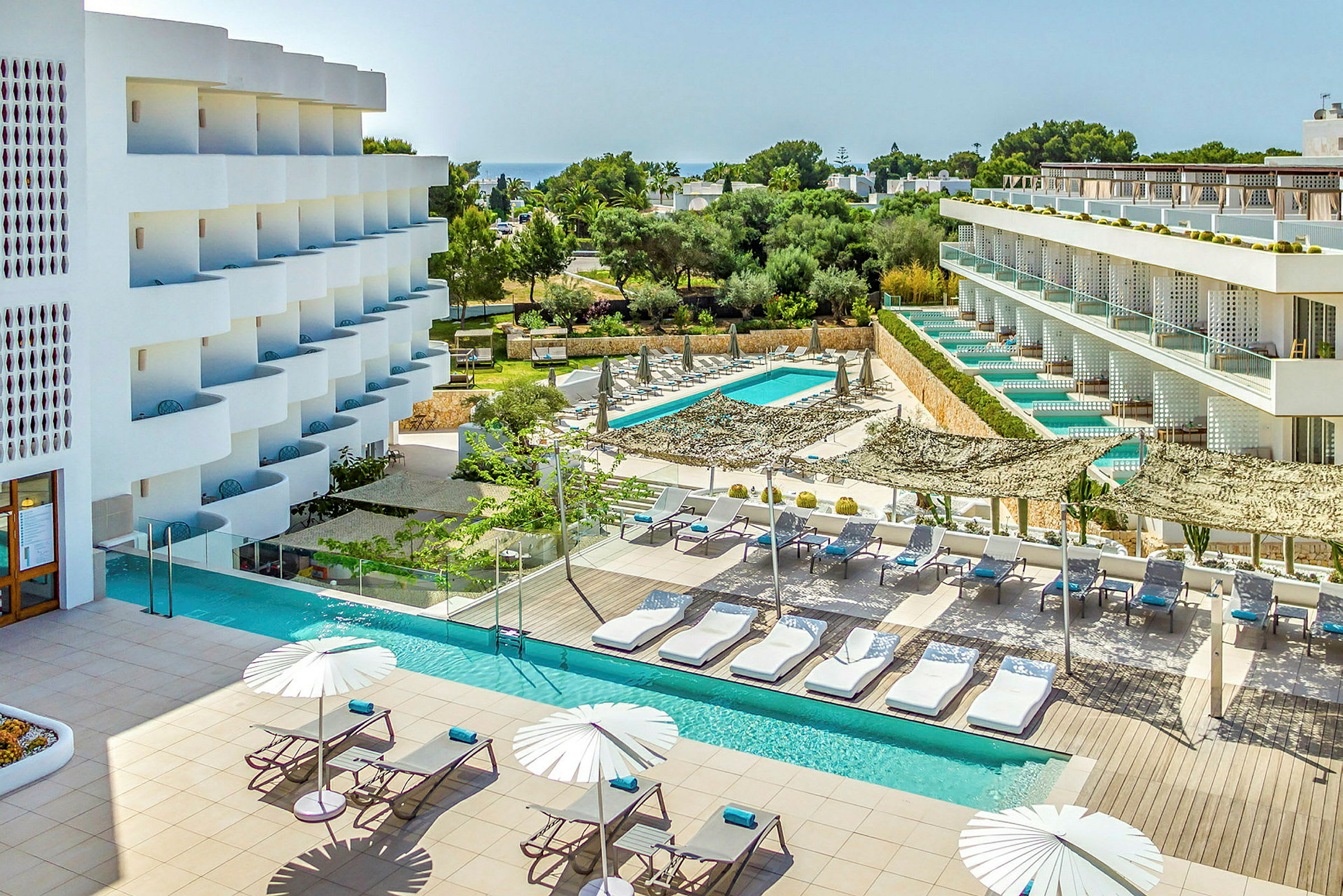 Et moderne hotel med poolområde og liggestole. (AI-genereret tekst)