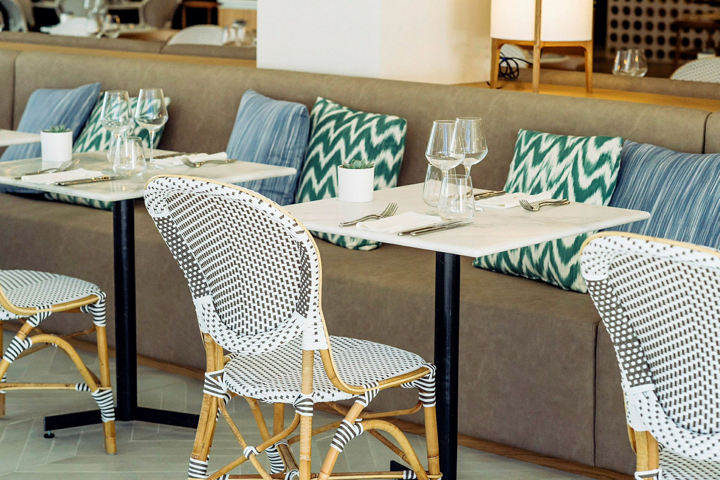 Restaurant med bordopsætning og puder. (AI-genereret tekst)